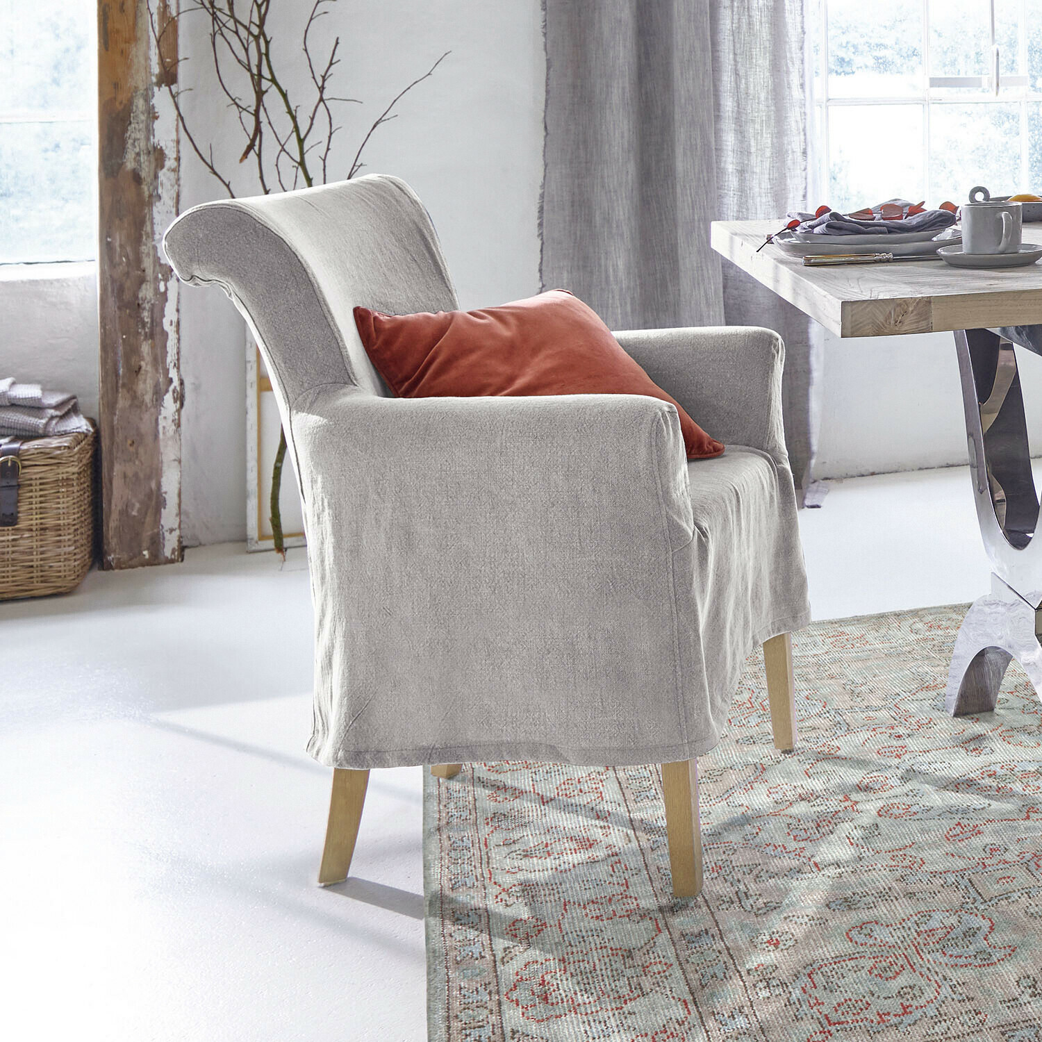 Chaise Amherst Fauteuil gris en tissu avec coussin rouge dans une salle à manger lumineuse et décorée