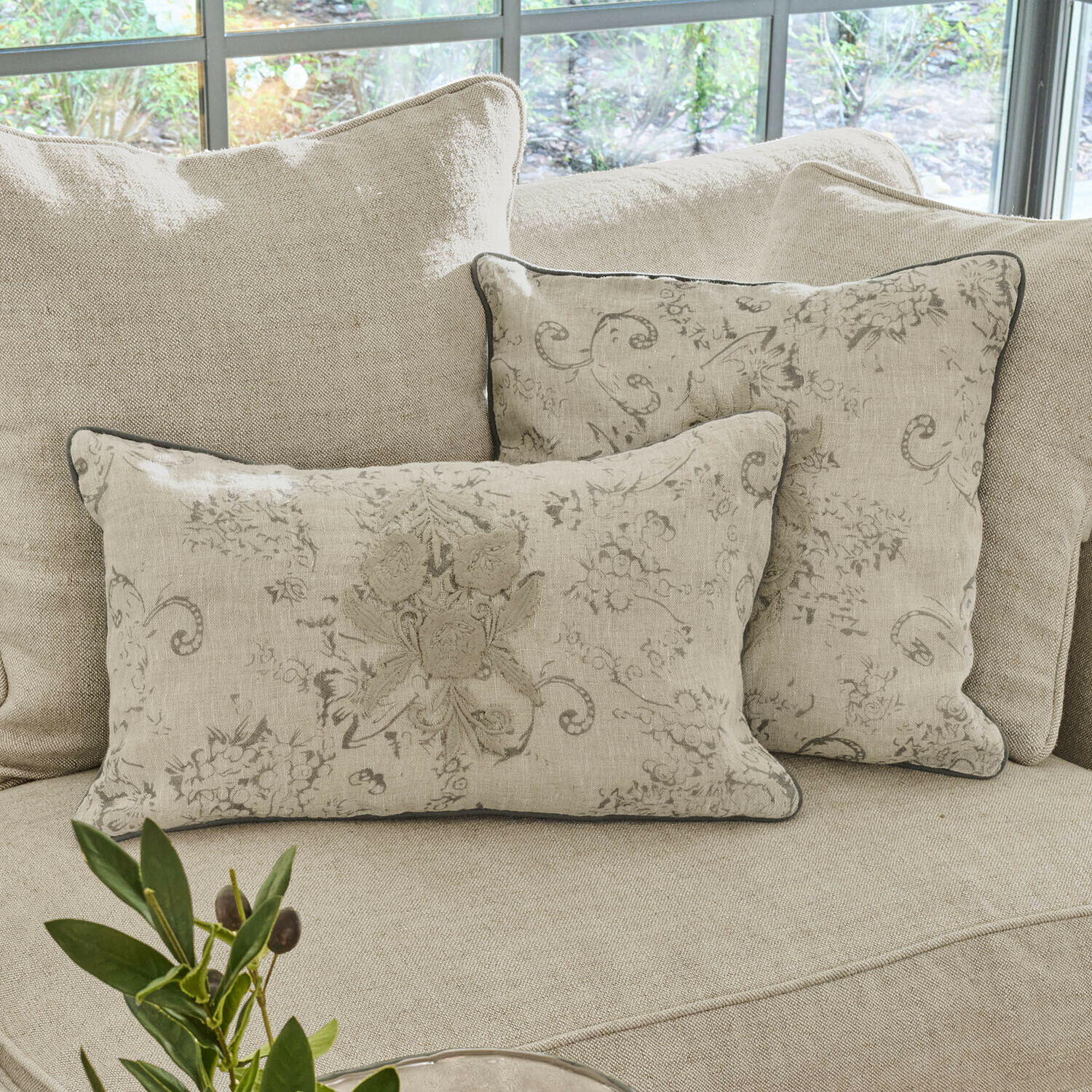 Lot de 2 housses de coussins Tenerosa Coussins décoratifs en lin beige avec motif floral sur canapé clair dans un salon lumineux