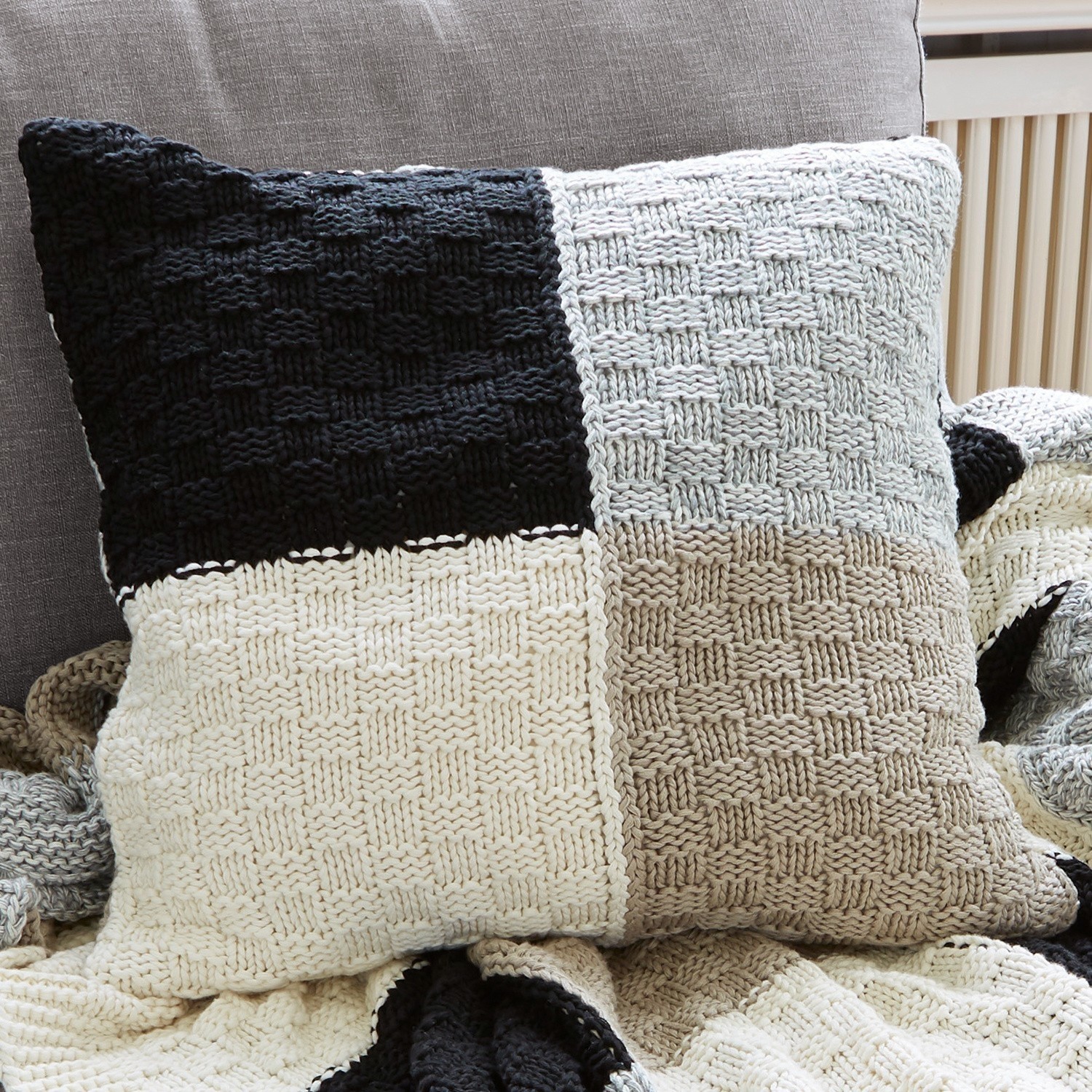 Coussin Tetbury Coussin carré en coton tricoté avec motifs carrés noir, blanc et beige, décoration intérieure