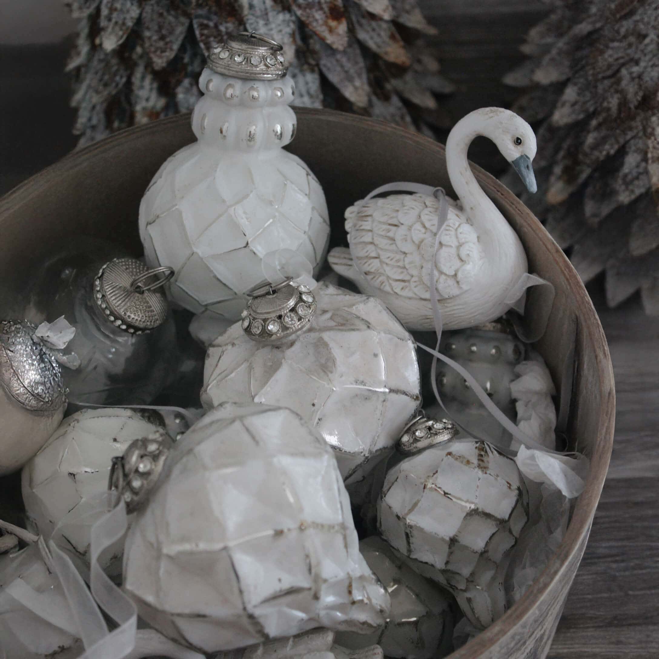 Décorations de Noël blanches en céramique et verre dans un bol en bois, ornements hivernaux