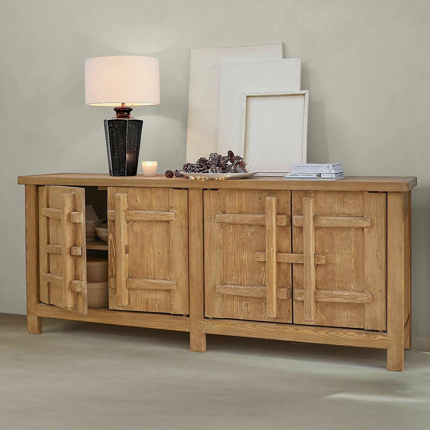 Buffet bas Trésorique Buffet en bois naturel avec quatre portes, lampe et décorations sur le dessus dans un intérieur moderne