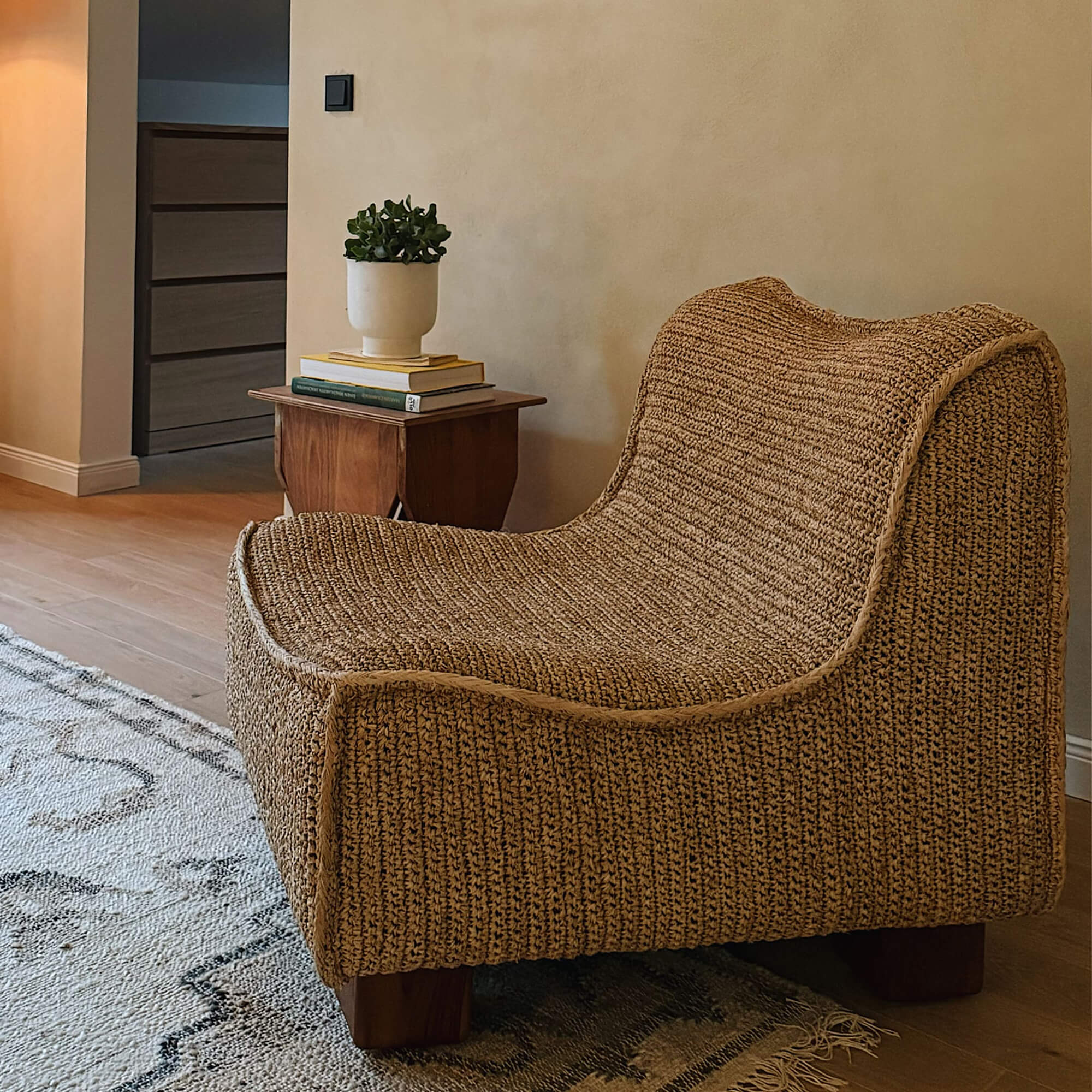Fauteuil marron en matériau tressé avec pieds en bois dans un salon moderne