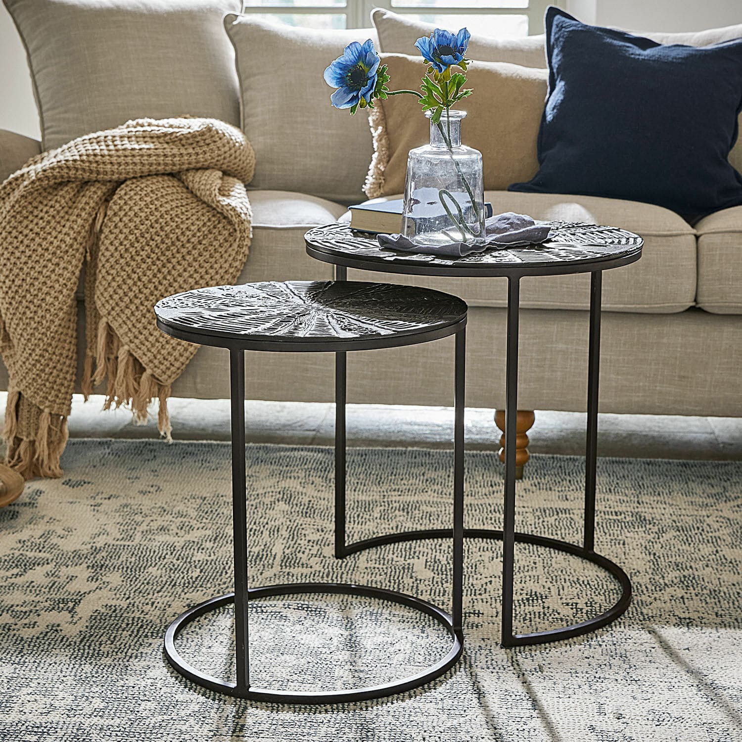 Lot de 2 tables d'appoint Petrosini Ensemble de deux tables basses en métal noir avec plateaux décoratifs dans un salon avec canapé beige