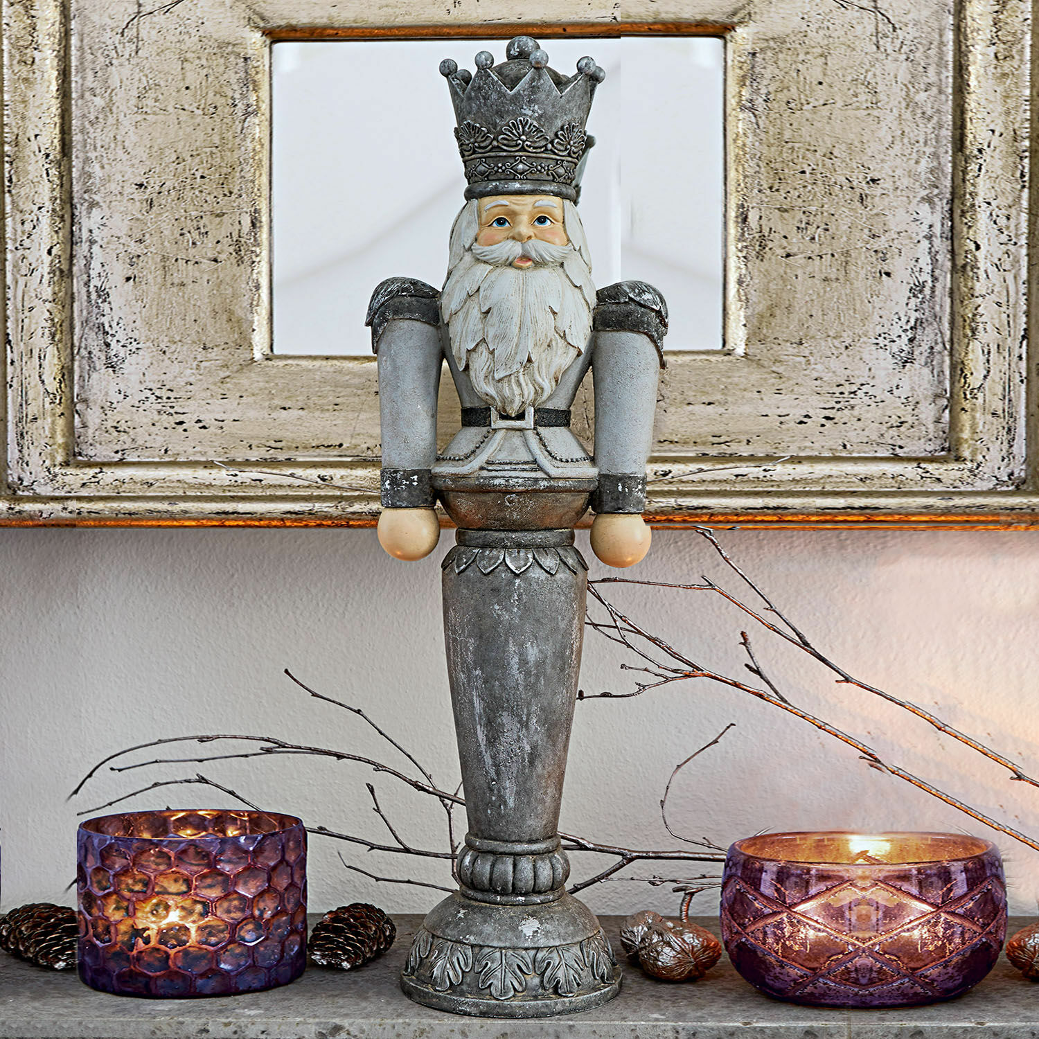 Figurine décorative Carter Figurine décorative de casse-noisette en métal gris posée sur une table avec des photophores violets