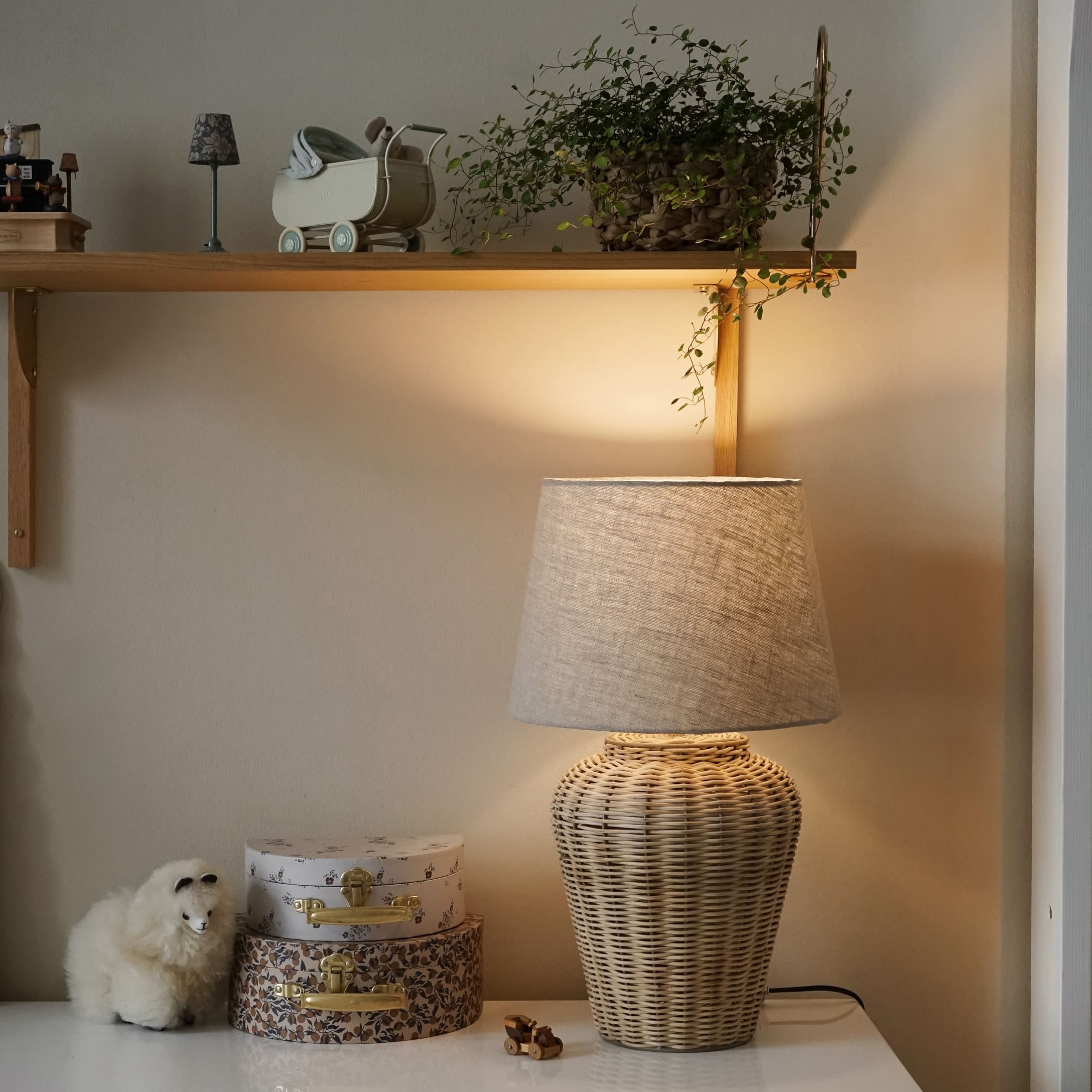 Lampe de table en rotin naturel avec abat-jour beige sur surface blanche avec décorations
