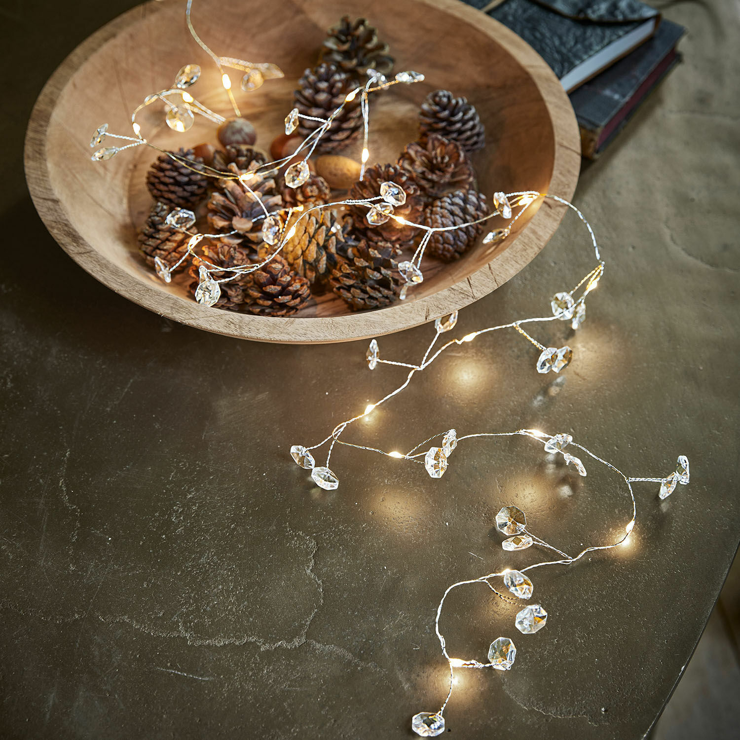 Guirlande lumineuse LED Laurits Bol en bois avec pommes de pin et guirlande lumineuse délicate à décor cristallin sur table