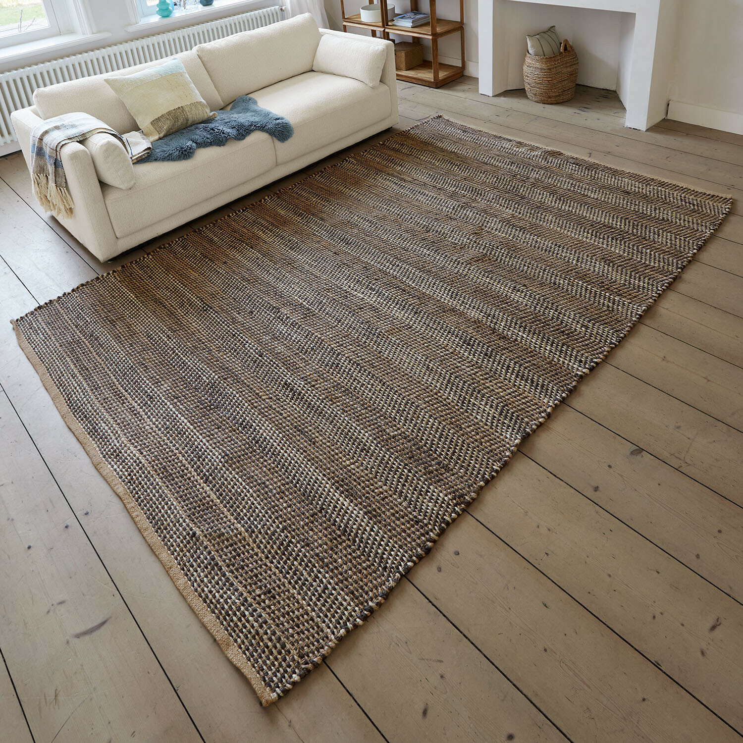Tapis Myråsen Tapis en matériau naturel aux tons marron et beige posé sur un sol en bois dans un salon lumineux