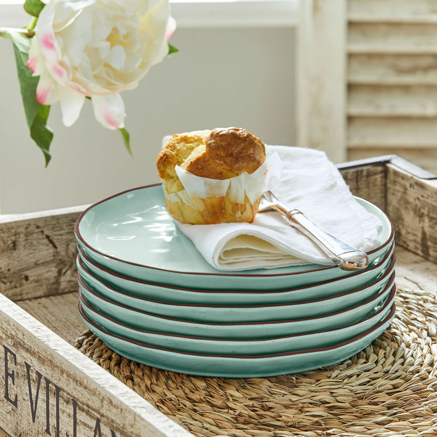 Lot de 6 assiettes à dessert Biarré Ensemble de six assiettes en céramique vert clair avec bord brun sur un plateau en bois avec un muffin