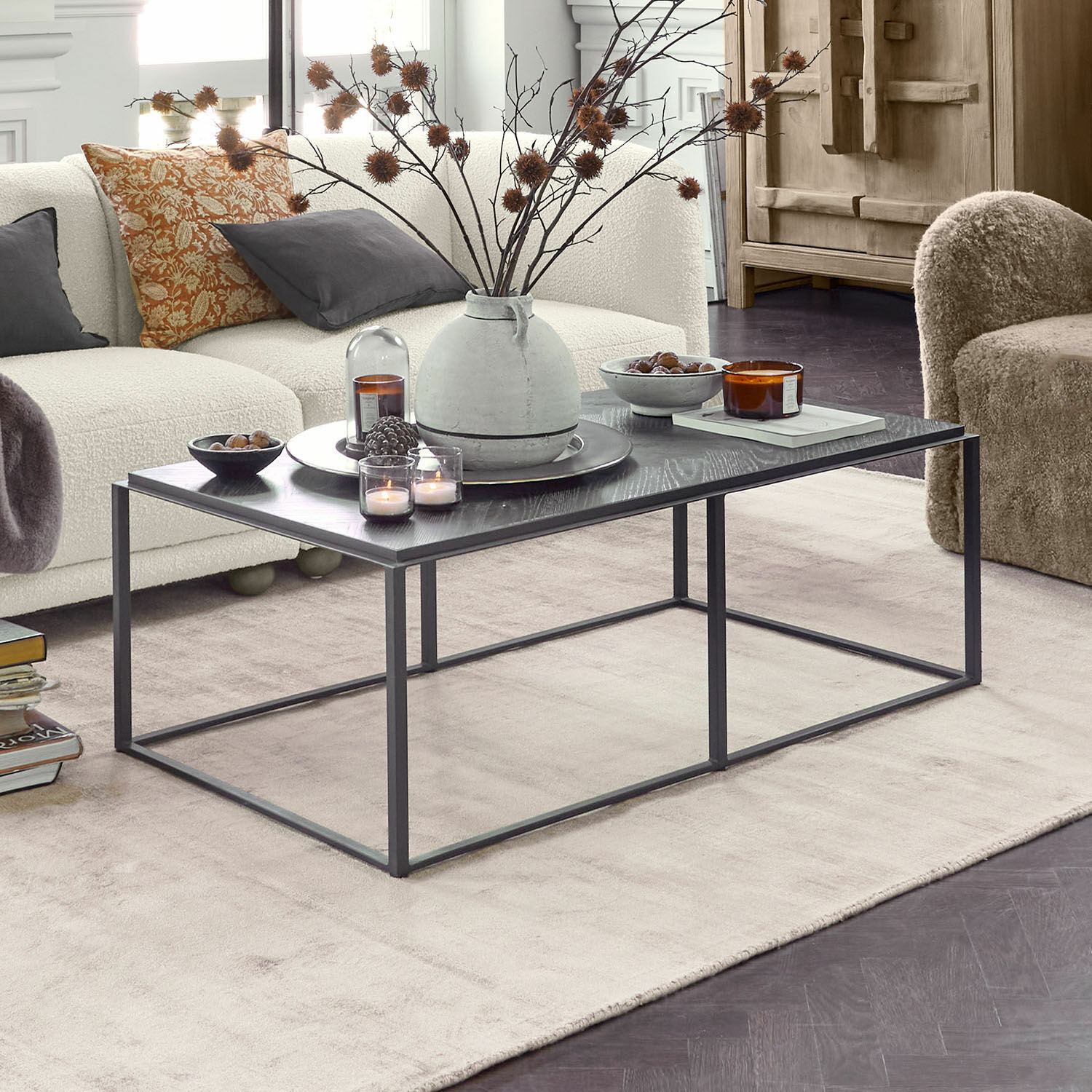 Table basse Lumesto Table basse noire moderne en métal avec décorations dans un salon clair avec canapé beige