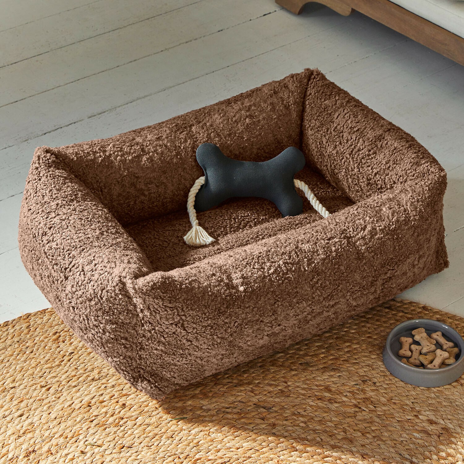 Lit pour animaux Giolena Panier pour chien en peluche marron avec jouet os noir et bol de friandises sur tapis tressé