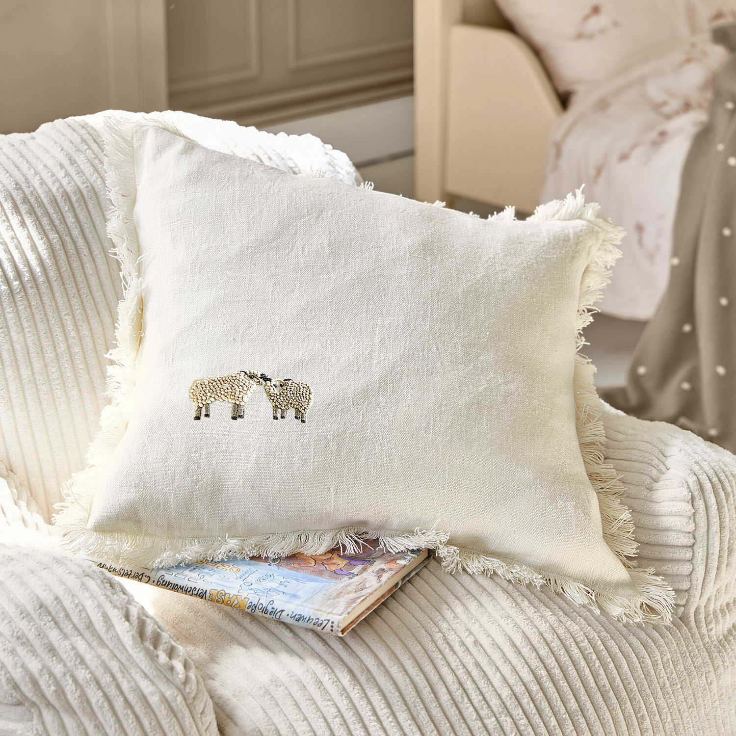 Housse de coussin Erianna Coussin beige en lin avec franges et broderie de moutons sur fauteuil doux, décoration maison