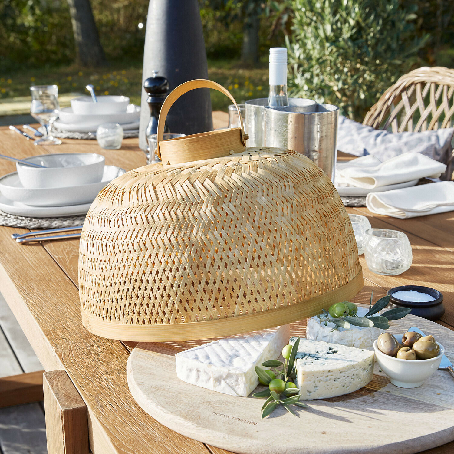 Cloche à fromage en bambou naturel avec poignée sur planche en bois pour repas en plein air