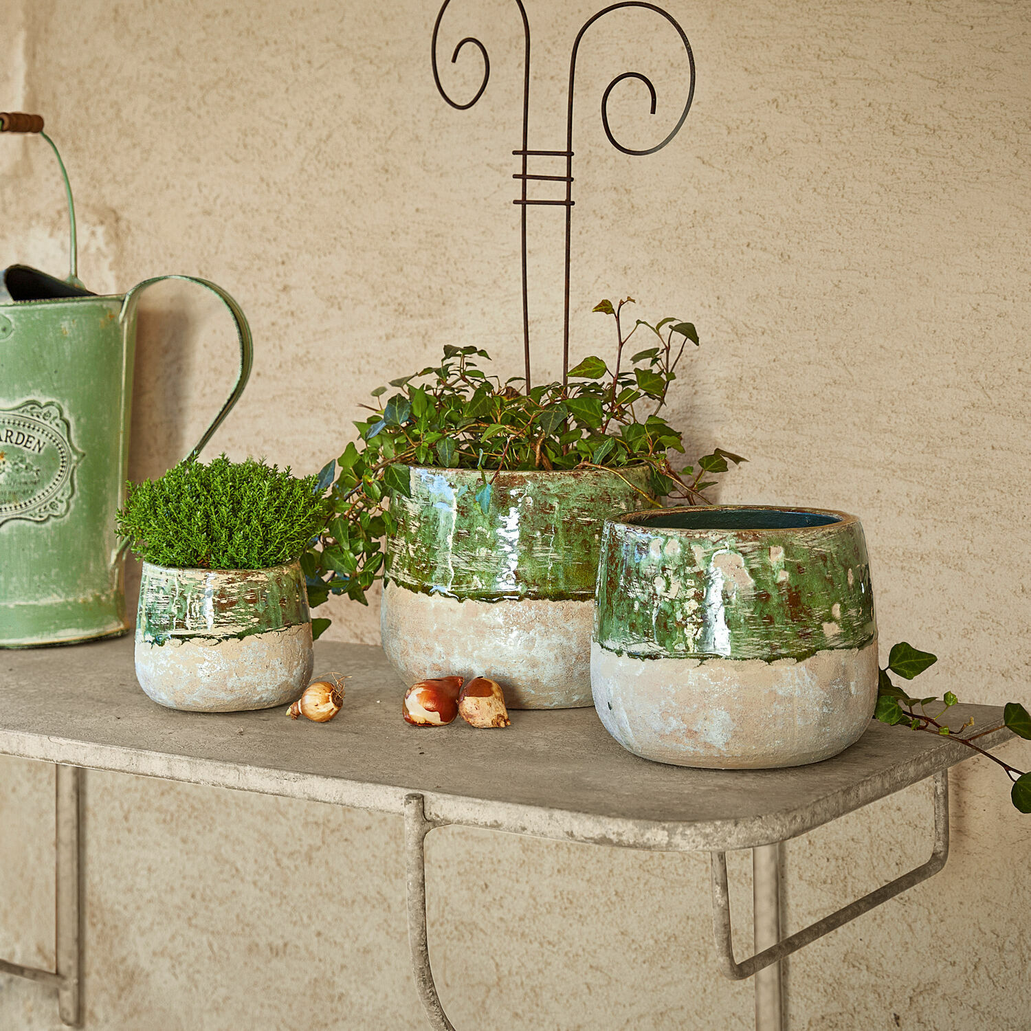 Lot de 3 cache-pots Reefton Ensemble de trois pots en céramique vert et beige sur une étagère métallique pour décoration de jardin