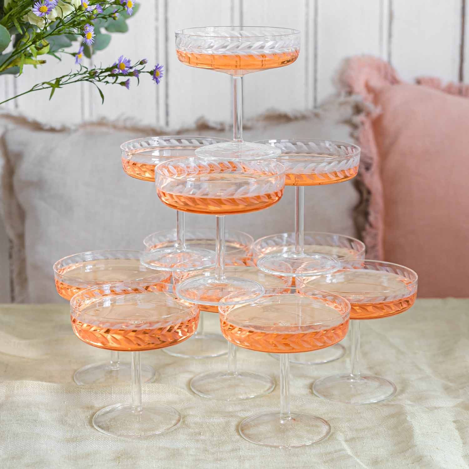 Ensemble de verres à champagne en cristal avec motif délicat et boisson rosée sur table