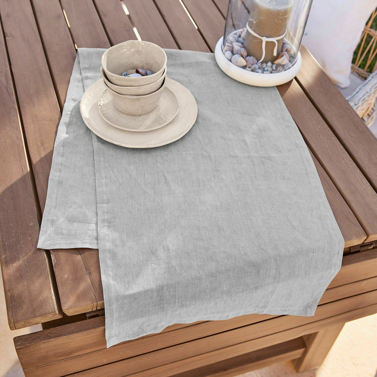 Chemin de table Bursinel Nappe en lin gris clair sur table en bois avec vaisselle en céramique et bougie décorative