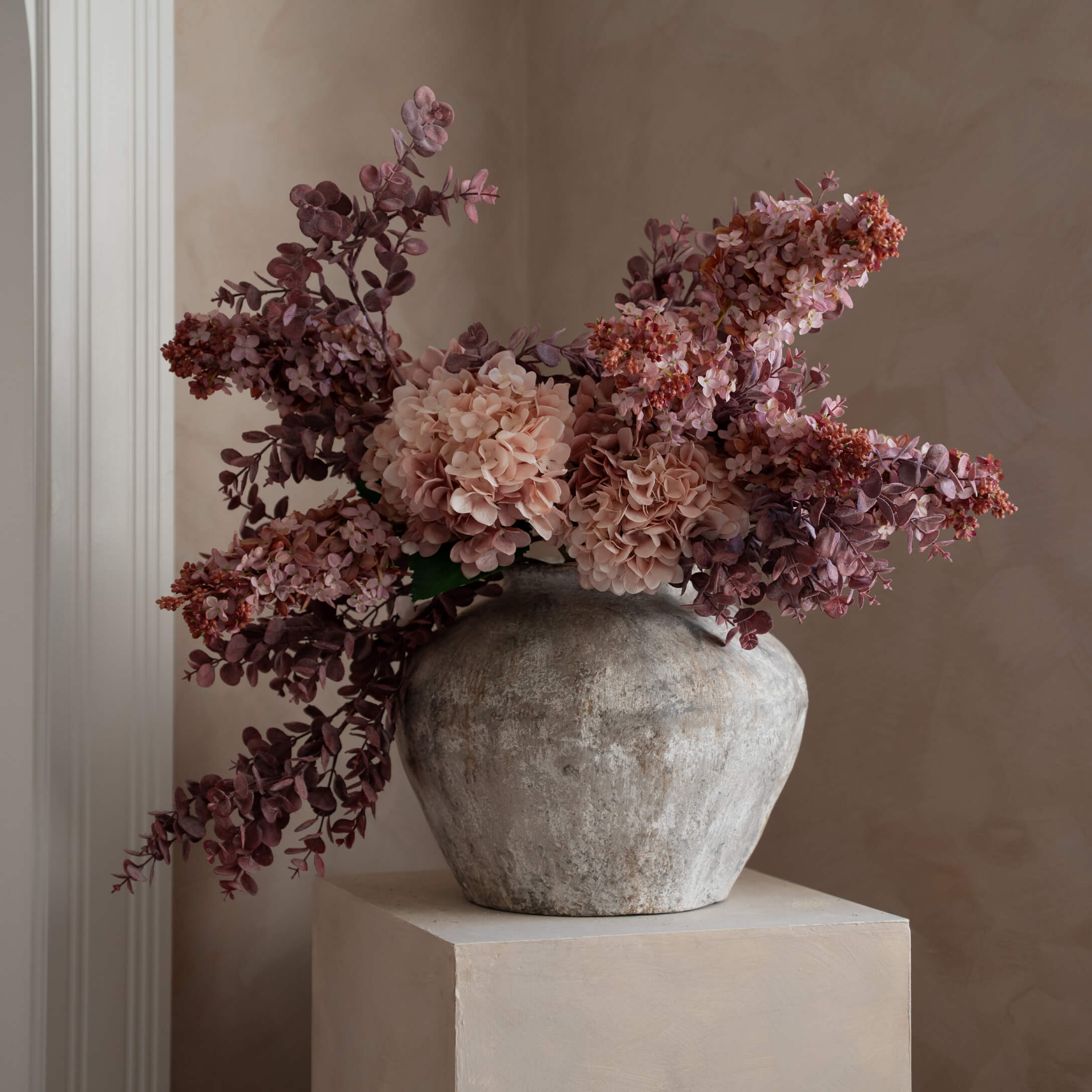 Vase décoratif en pierre grise avec fleurs artificielles roses et violettes pour décoration intérieure