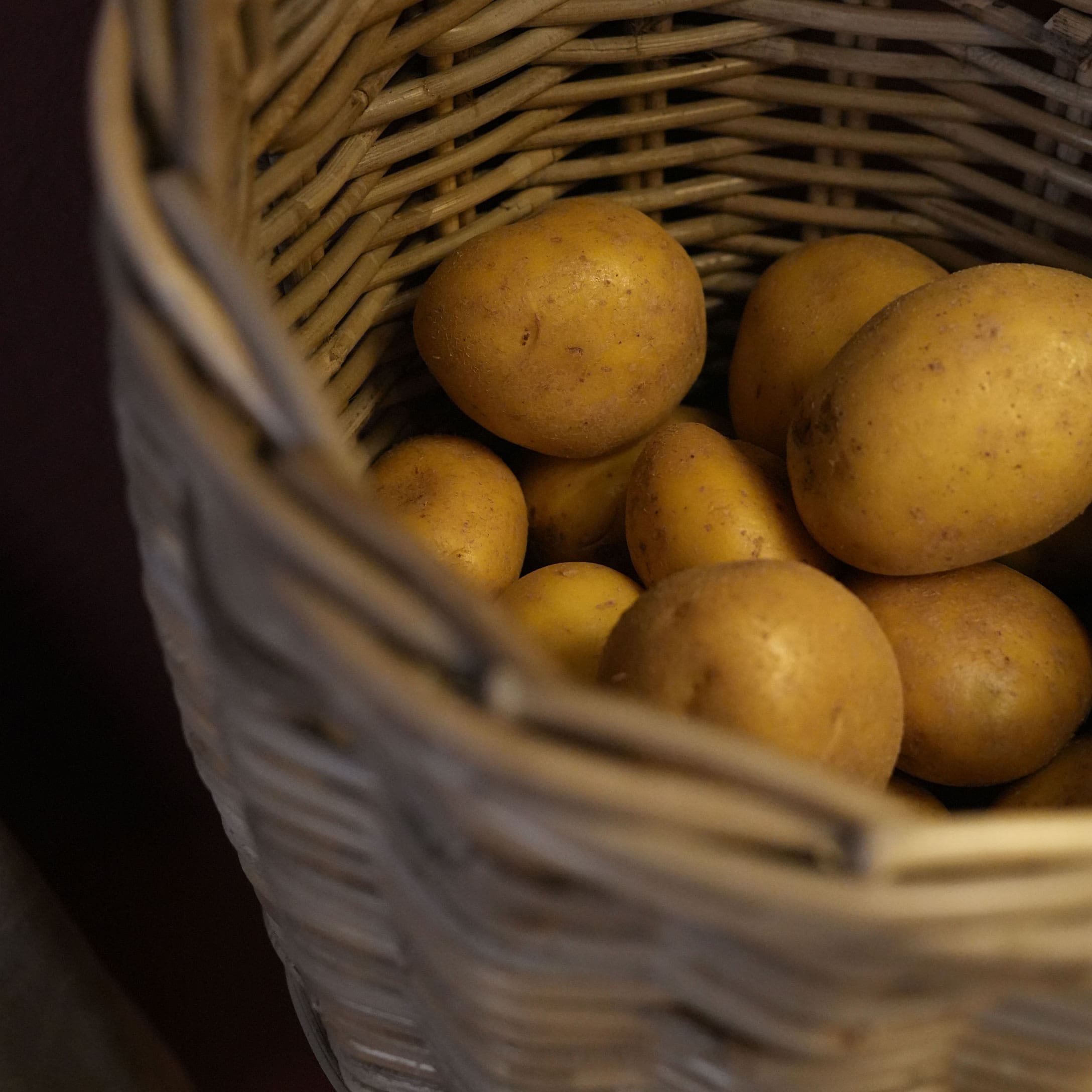 Pommes de terre fraîches dans un panier en osier naturel, légumes pour cuisine
