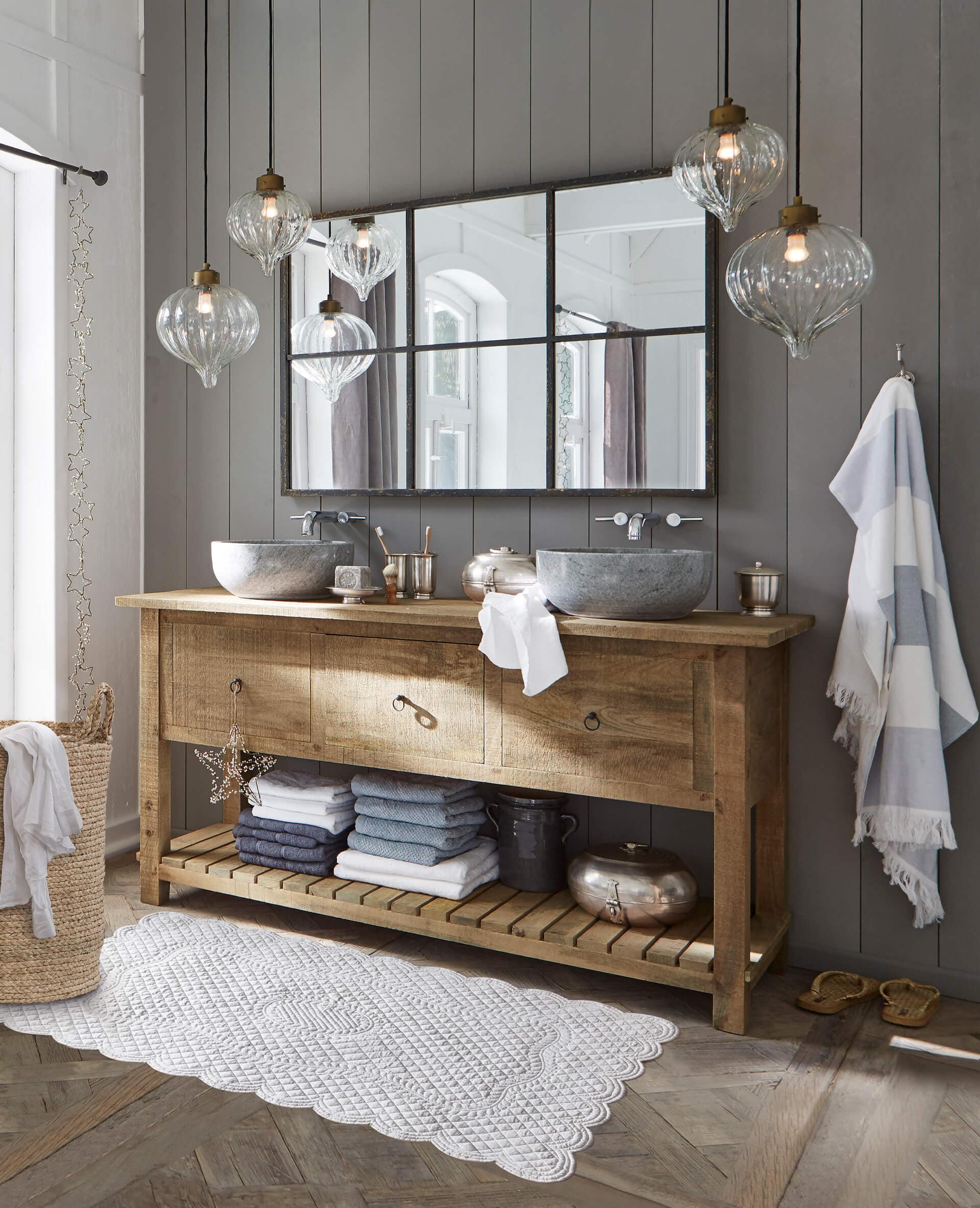 Meuble de salle de bain en bois avec vasques en pierre et serviettes grises dans un style rustique
