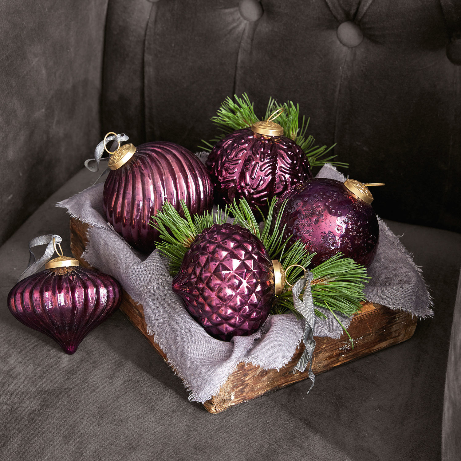 Lot de 5 suspensions de Noël Sambre Ensemble de boules de Noël en verre violet avec branches vertes dans une caisse en bois sur fond gris
