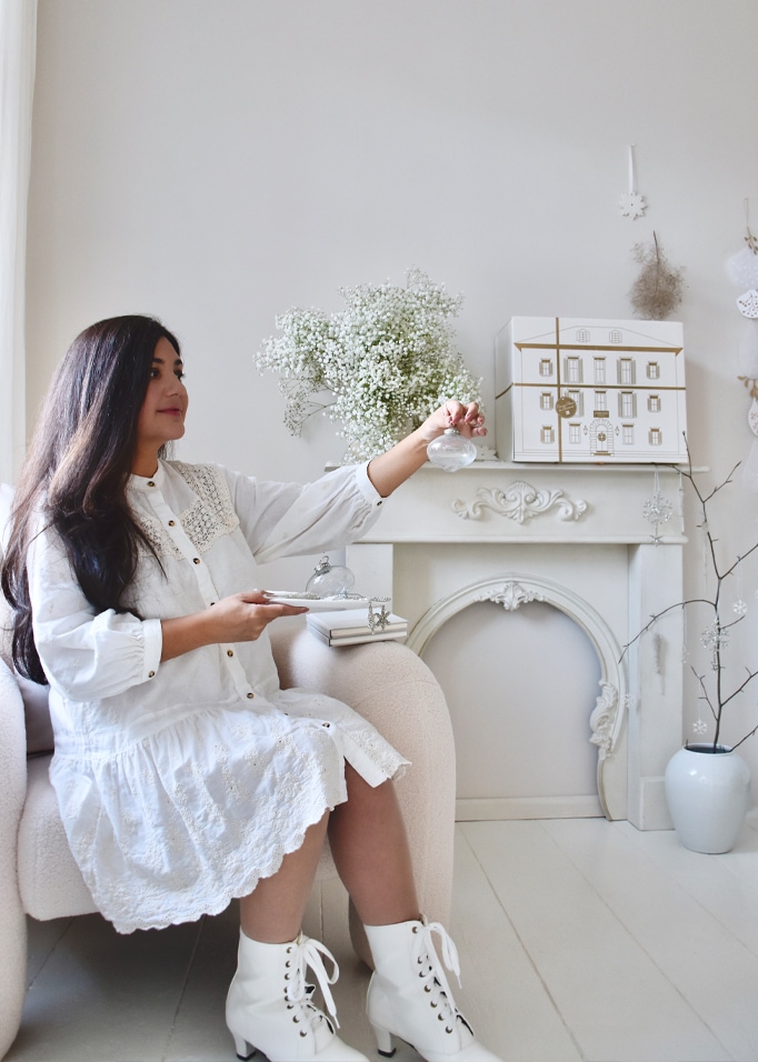Décoration intérieure féminine avec une console de cheminée blanche et des ornements délicats dans un salon clair