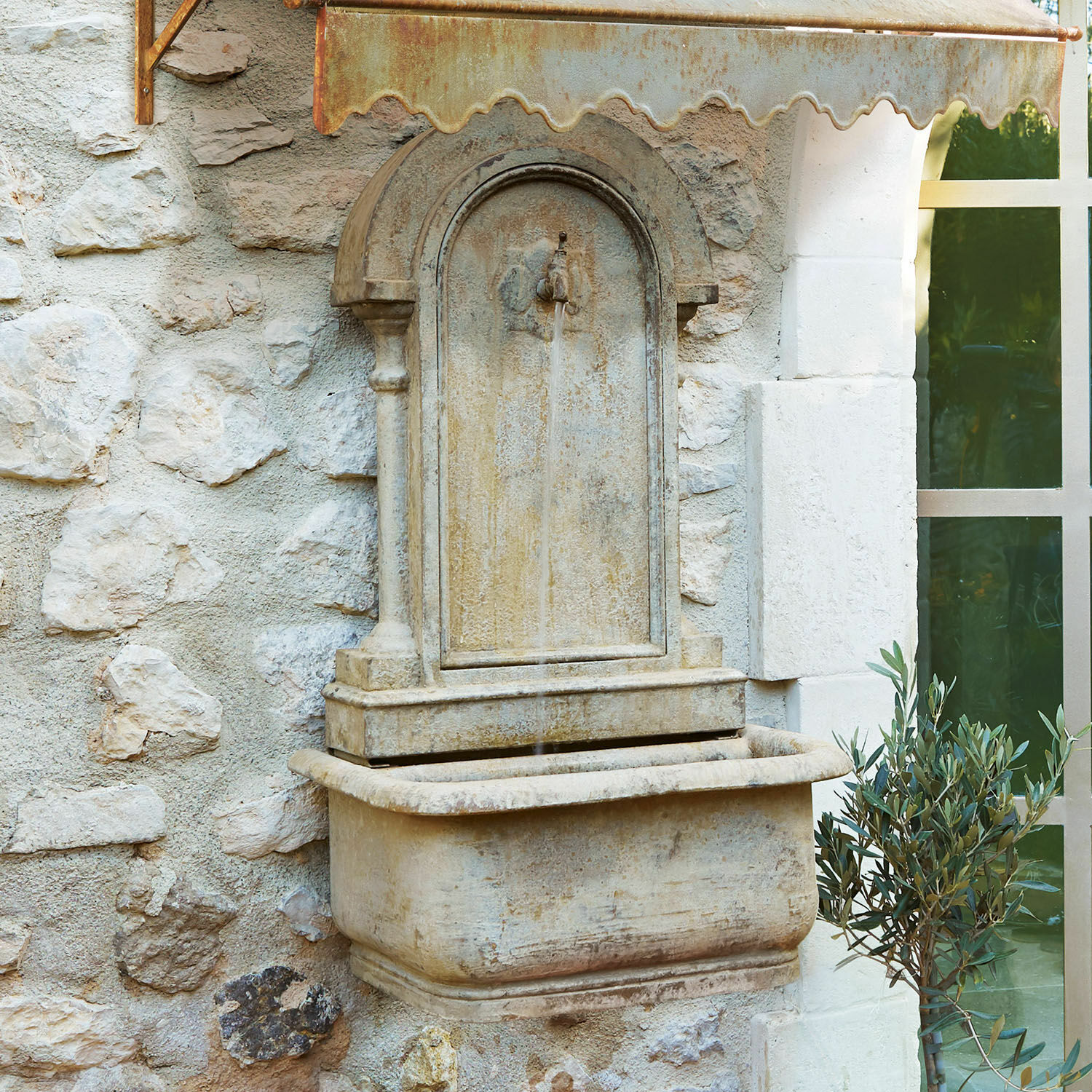 Fontaine murale Ivera Fontaine murale en pierre beige avec auvent métallique rouillé et jet d'eau décoratif extérieur