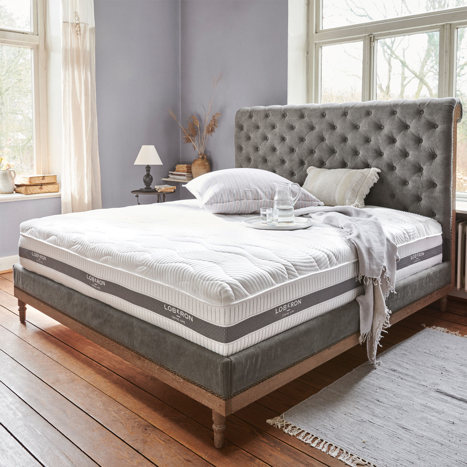 Matelas avec surmatelas 180x200 Raillimont Lit tapissé gris avec tête de lit capitonnée et matelas blanc Loberon dans une chambre lumineuse