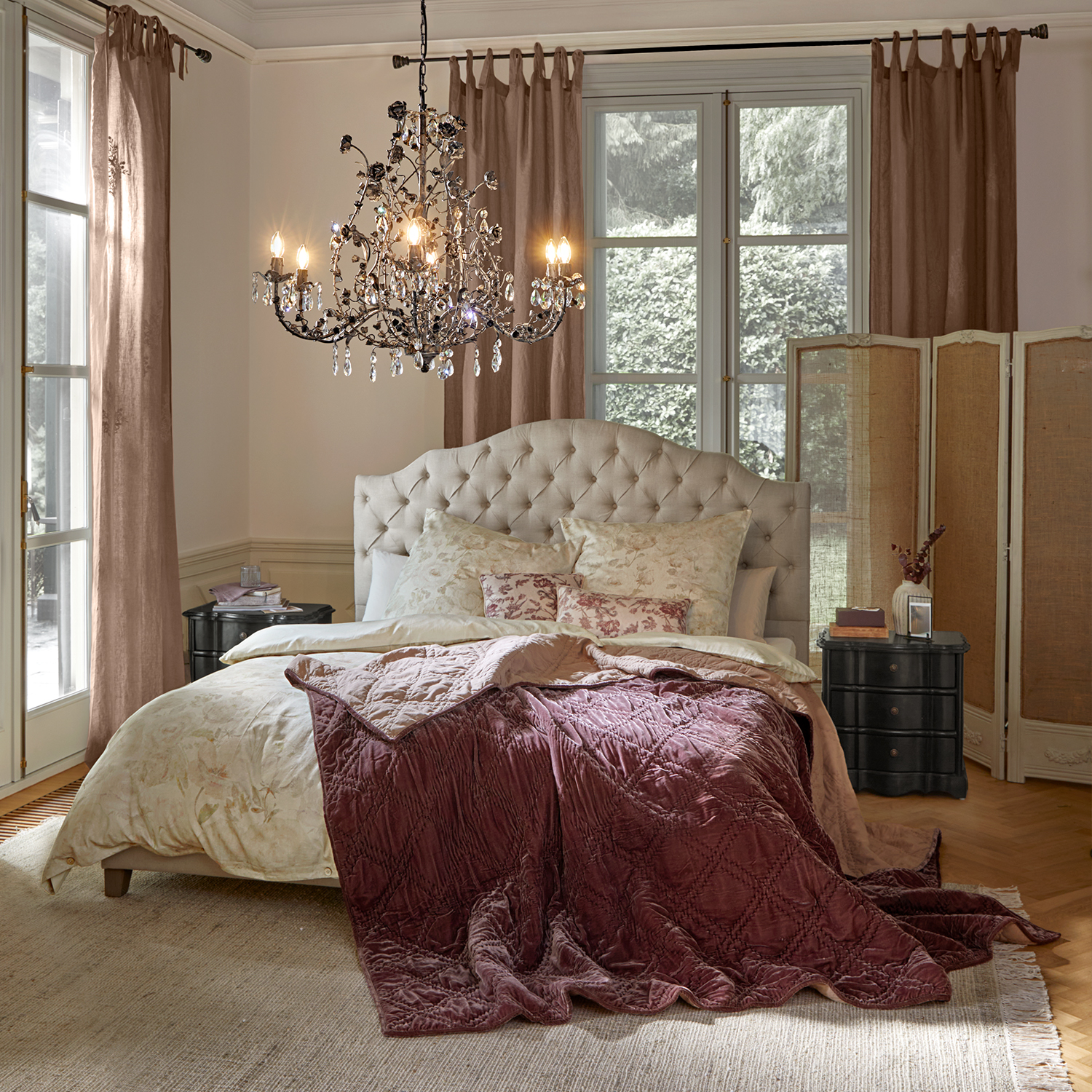 Chambre chaleureuse avec tête de lit beige capitonnée et couverture en velours bordeaux sur le lit