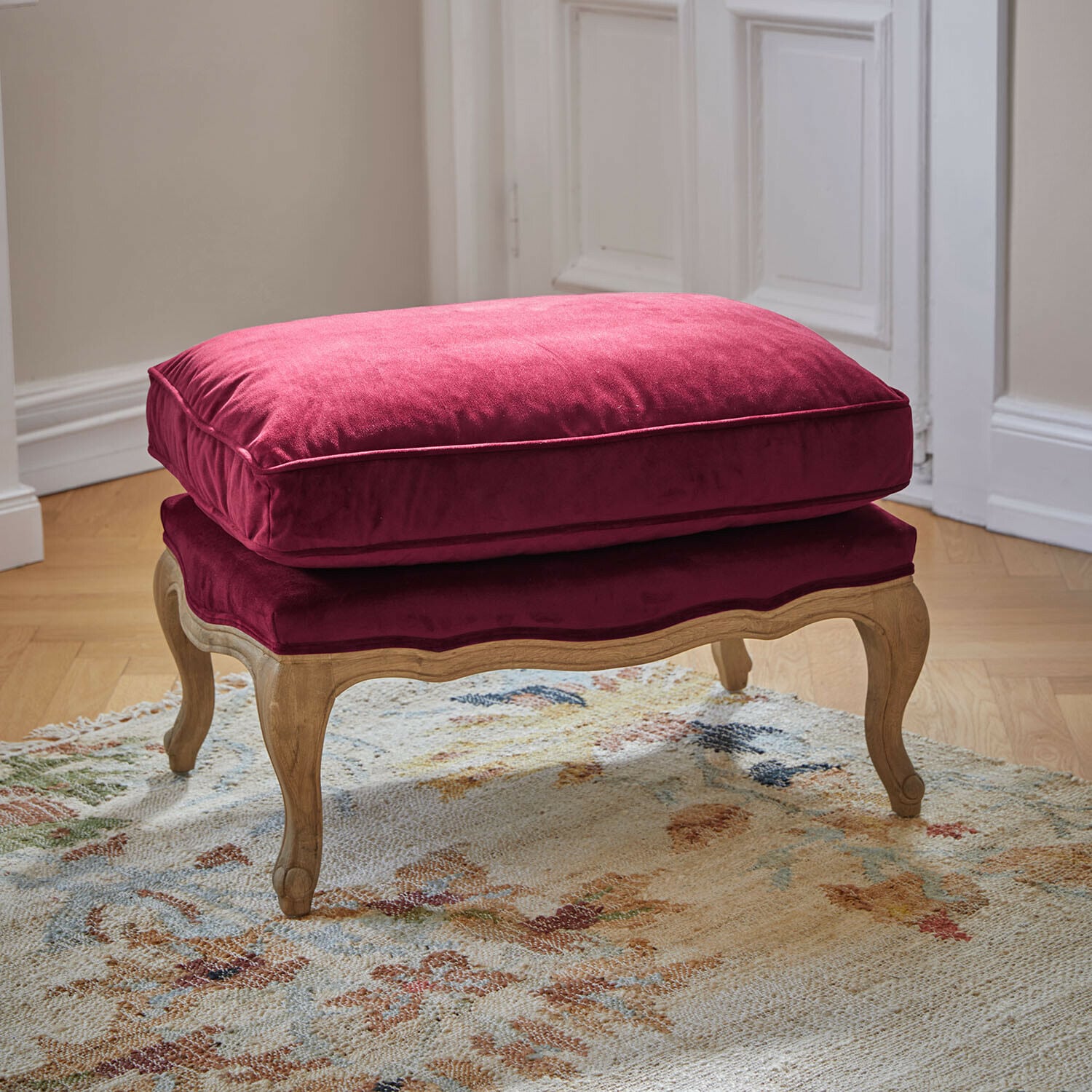 Tabouret Corlay Repose-pieds en bois avec coussin en velours bordeaux, parfait pour un salon élégant