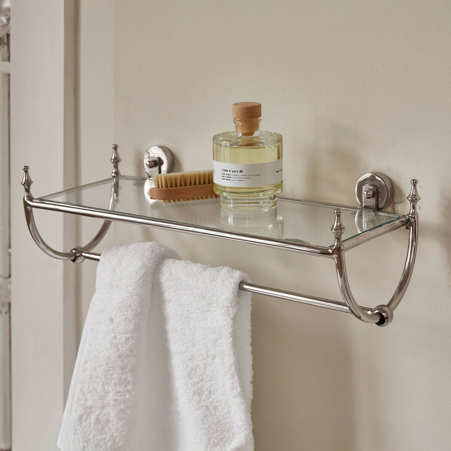 Étagère de salle de bain en acier inoxydable avec tablette en verre, serviette blanche, brosse et flacon d'huile