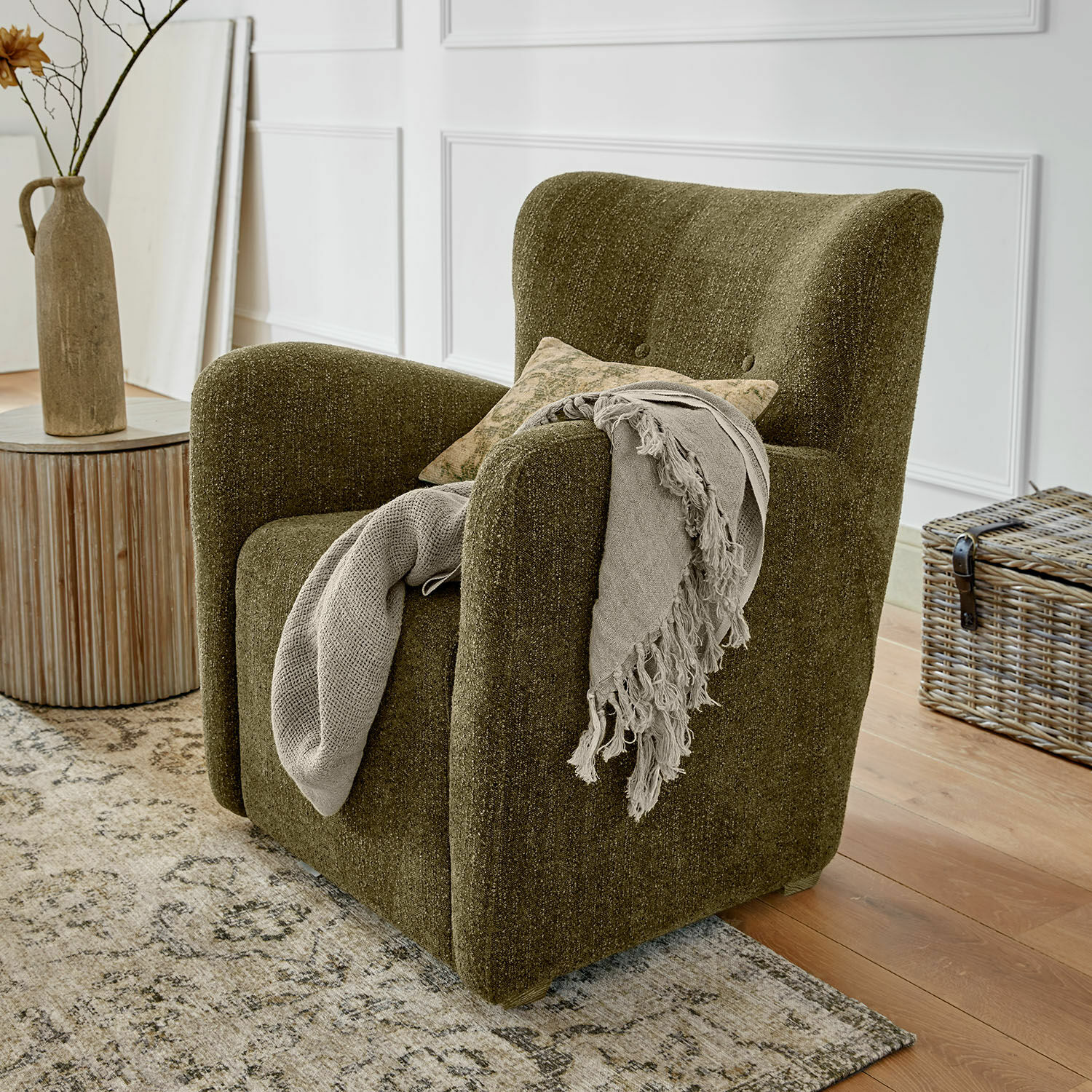 Fauteuil Somberac Fauteuil vert en tissu doux style vintage avec plaid décoratif dans un salon lumineux