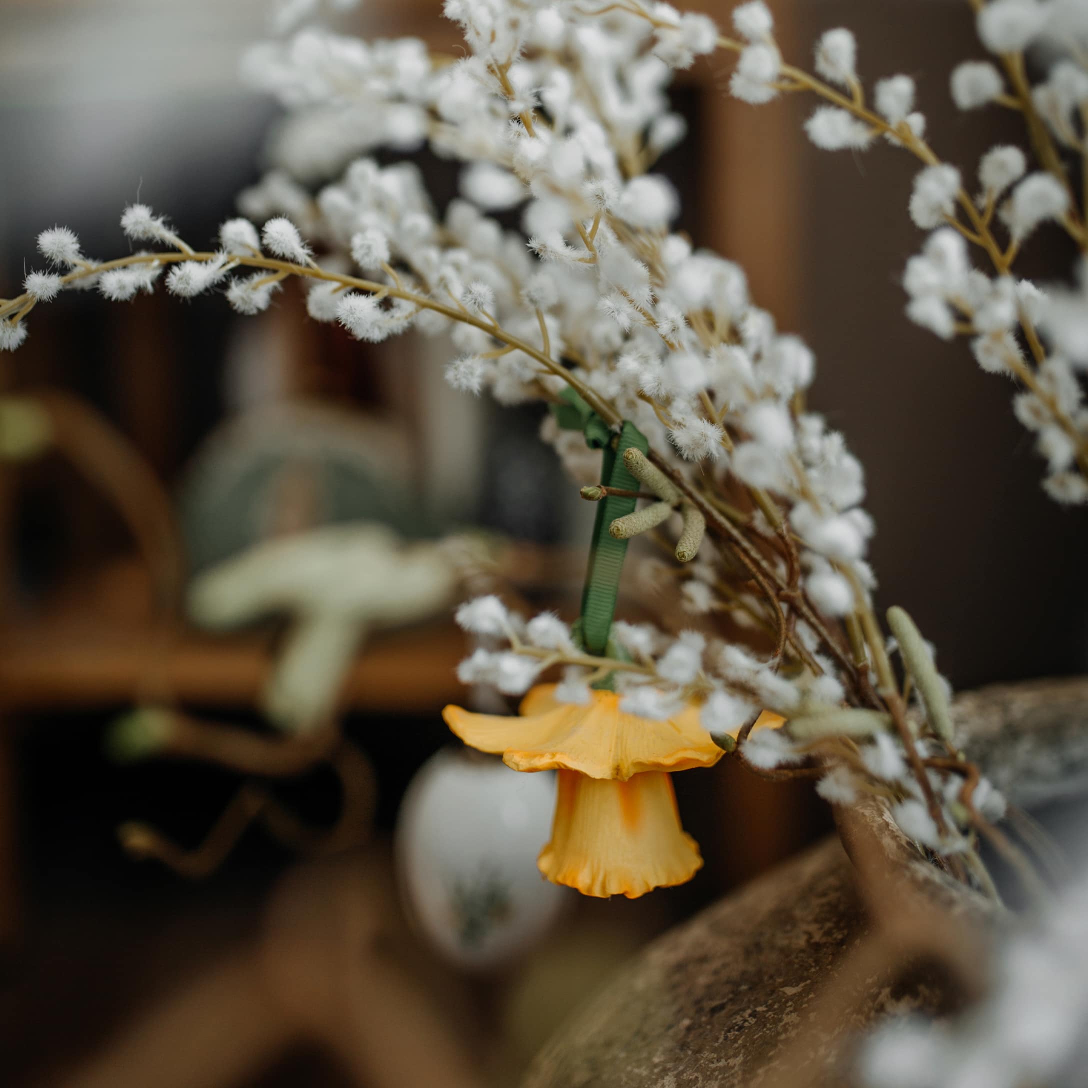 Branche décorative avec fleurs blanches duveteuses et fleur jaune pour décoration printanière intérieure