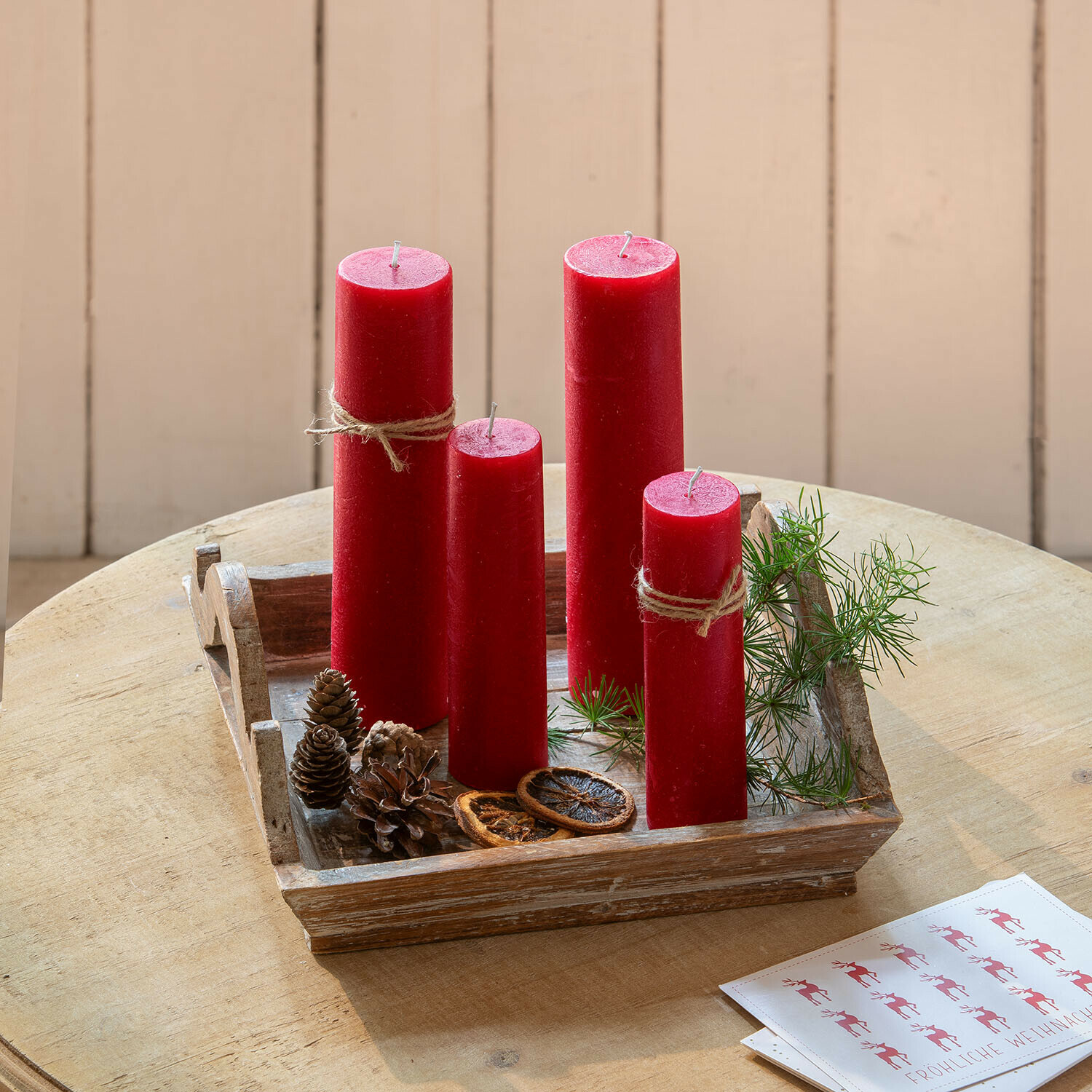 Lot de 4 bougies Avinal Bougies rouges en cire sur un plateau en bois avec décorations naturelles et branches vertes