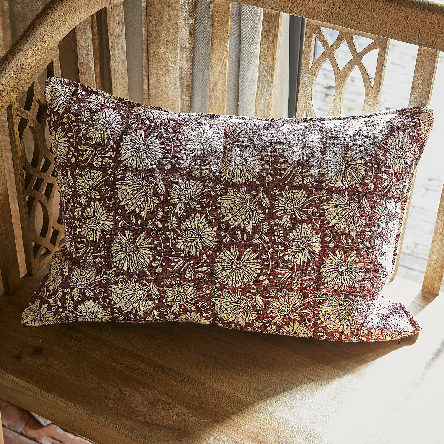Housse de coussin Soleique Coussin décoratif rectangulaire en tissu rouge avec motif floral crème posé sur une chaise en bois