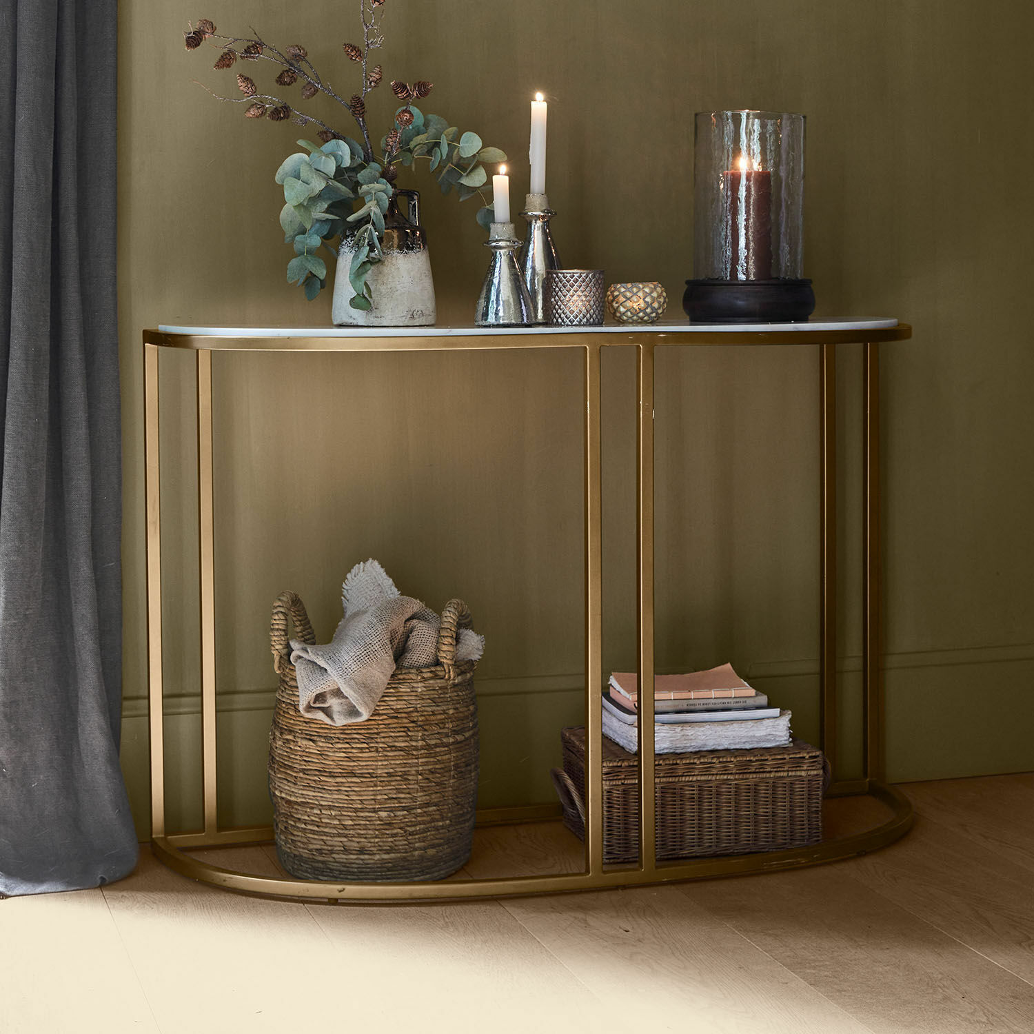 Console Soréline Console avec plateau en marbre blanc et cadre métallique doré, décorée de bougies et vase avec feuillage vert