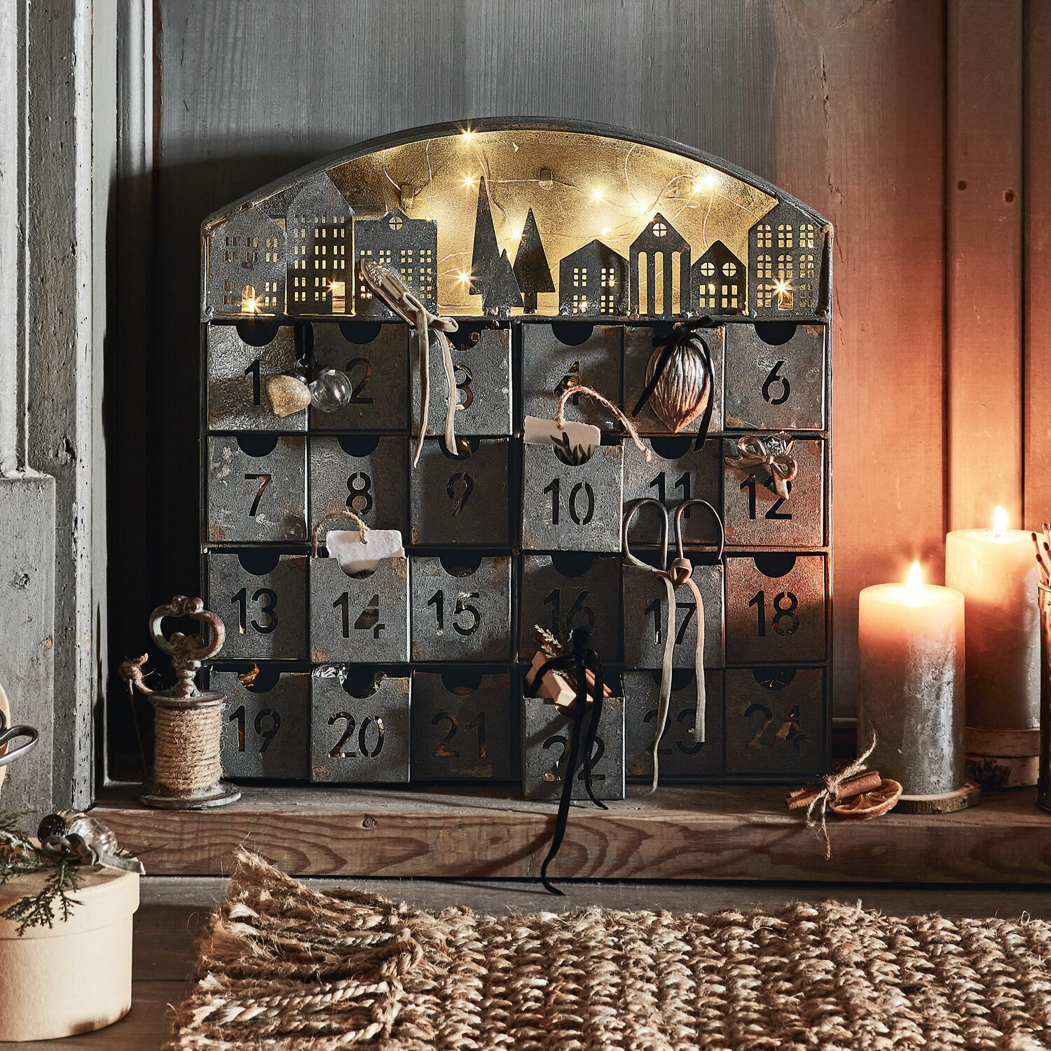 Calendrier de l’Avent Léran Calendrier de l'Avent en métal avec 24 tiroirs numérotés et décor de maisons éclairé par des bougies