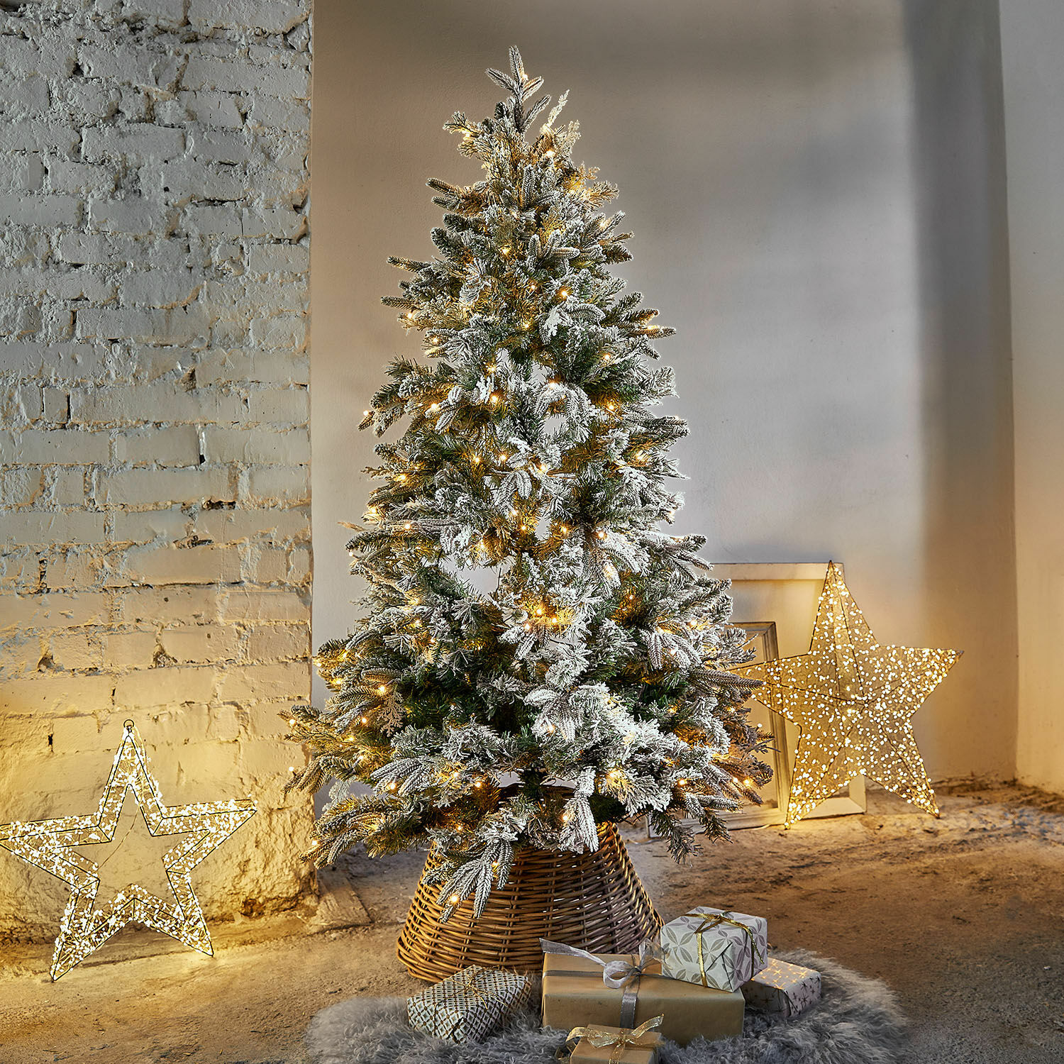 Sapin de Noël Cadelise Sapin artificiel enneigé avec guirlandes LED chaudes sur socle en osier, décoré de cadeaux au pied