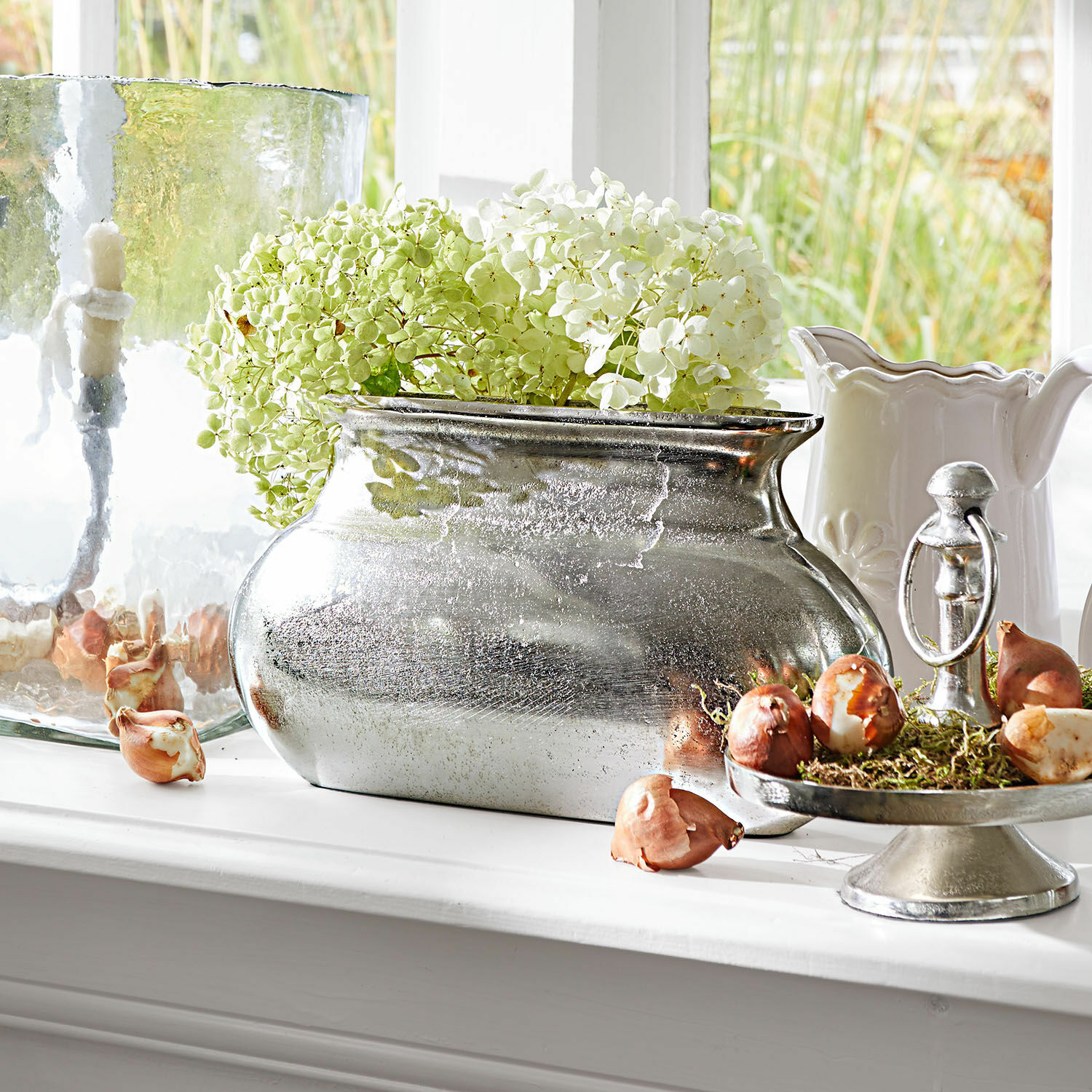 Vase Melisique Vase en métal argenté avec hortensias verts et blancs sur rebord de fenêtre avec bulbes décoratifs