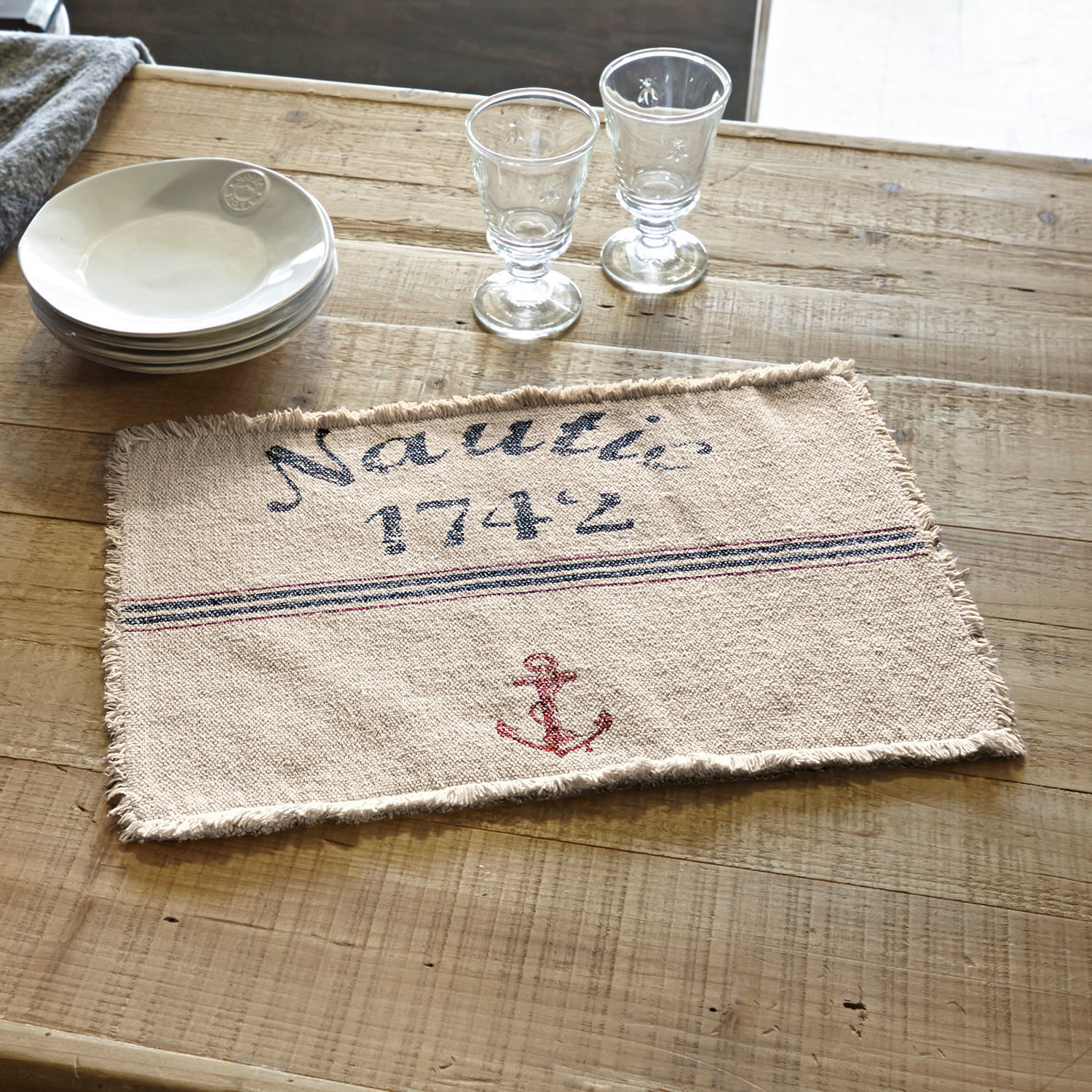 Lot de 2 sets de table Nautic Set de table en coton beige avec ancre rouge et inscription Nautic 1742 sur table en bois