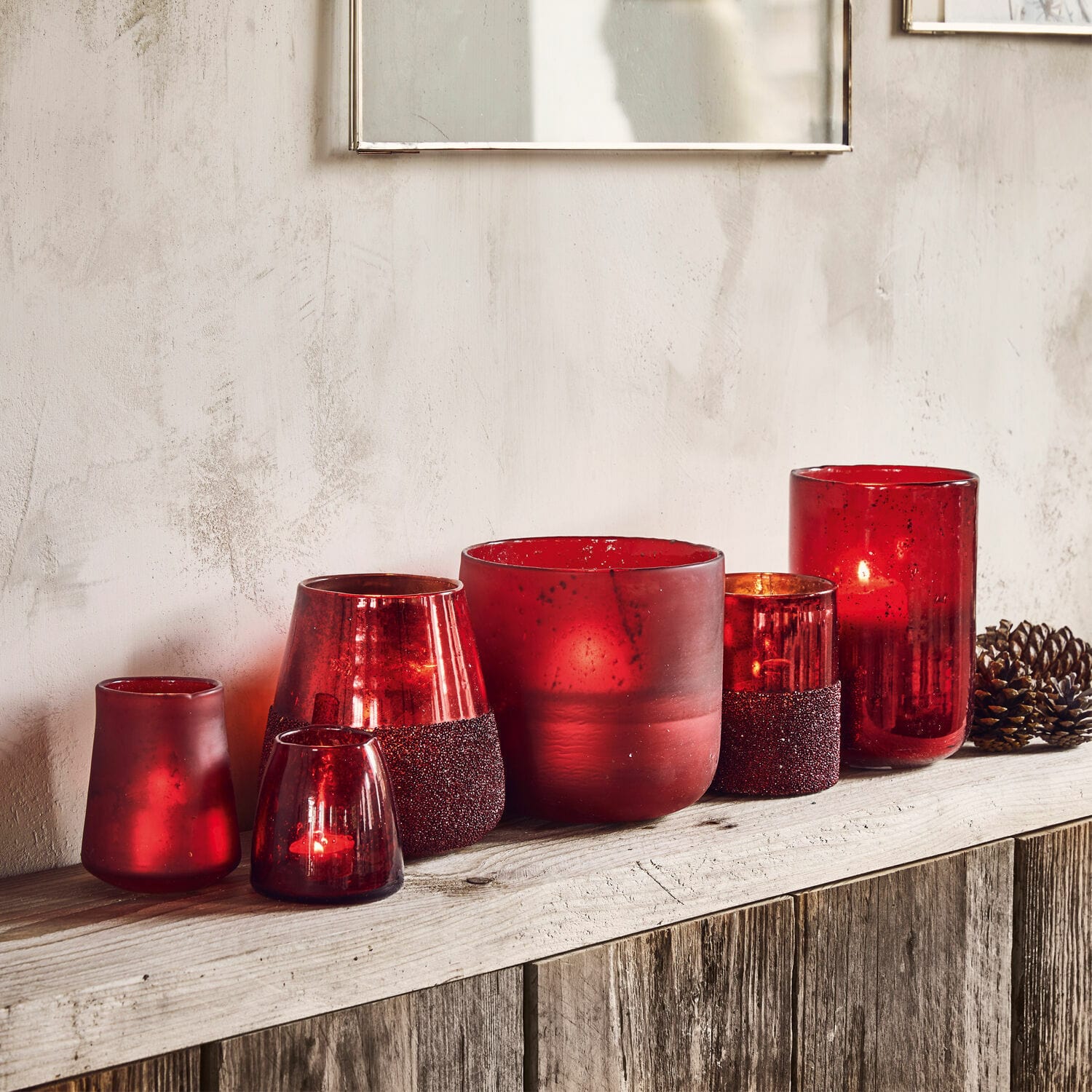 Lot de 6 photophores Paro Ensemble de photophores en verre rouge décoratif posés sur une étagère en bois rustique