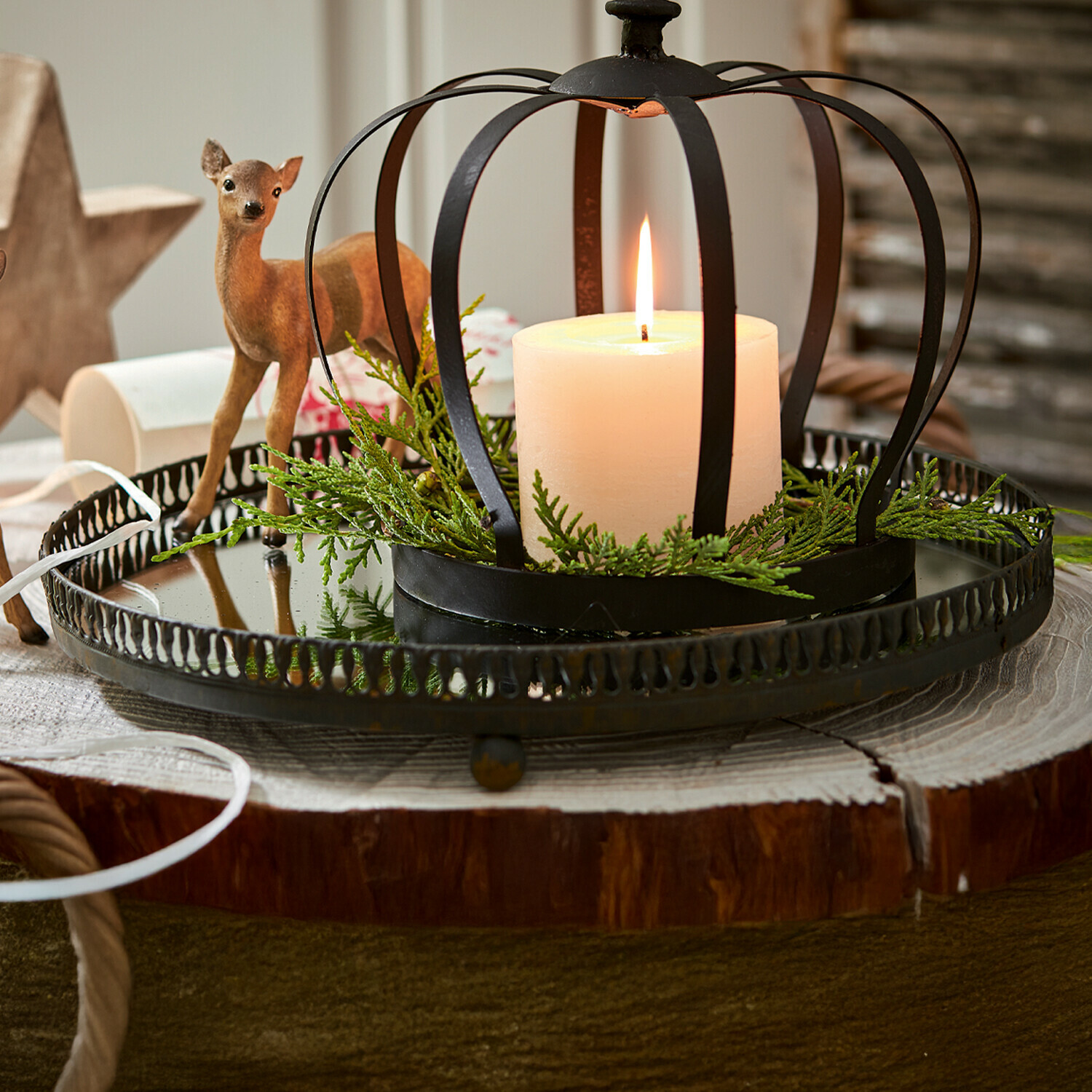 Plateau Tano Bougeoir en métal noir en forme de couronne avec bougie blanche et branches vertes sur base en bois