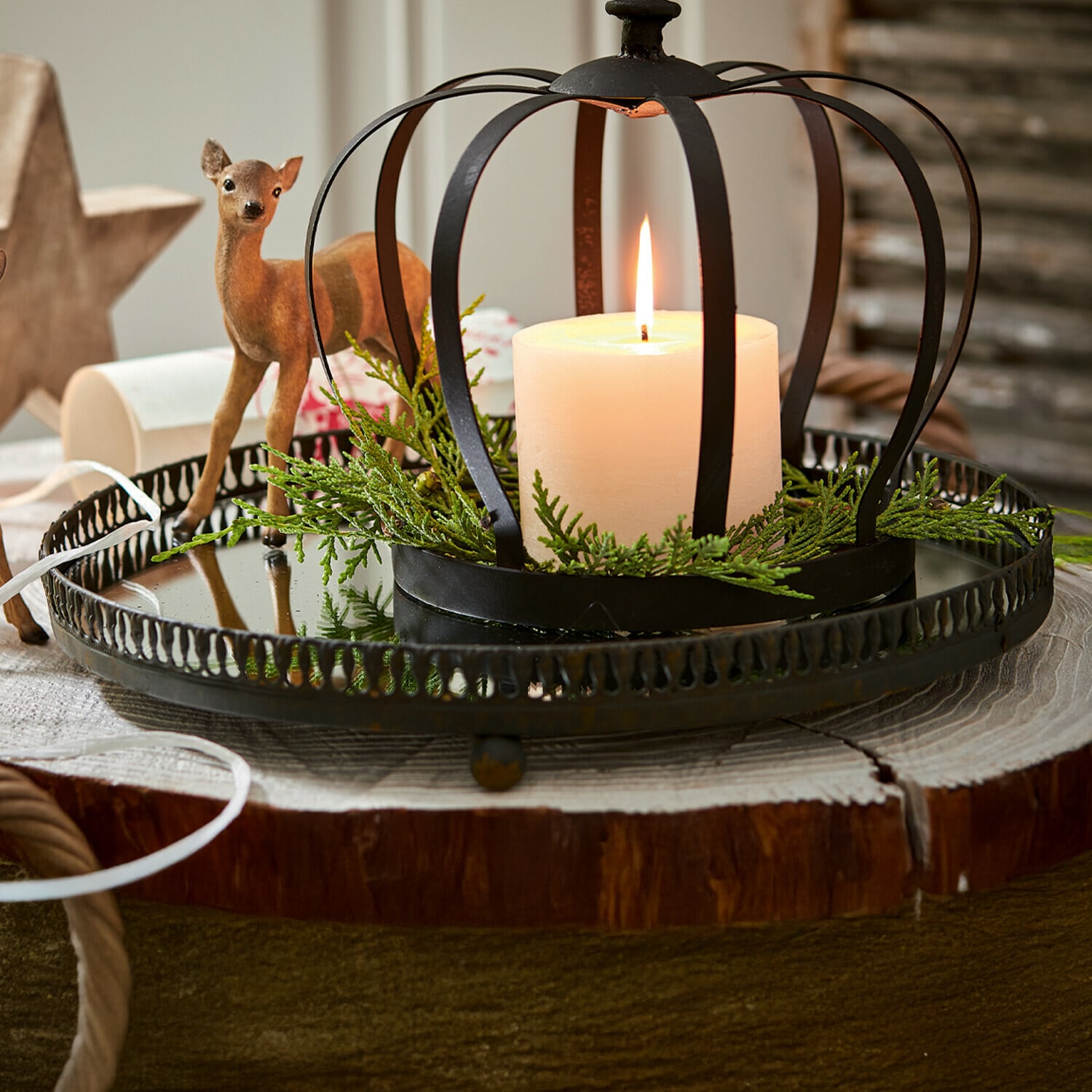 Plateau Tano Bougeoir en métal noir en forme de couronne avec bougie blanche et branches vertes sur base en bois