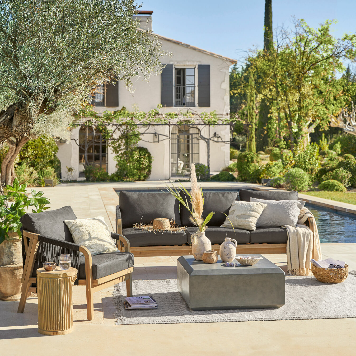 Salon de jardin FSC®-100% Shreveport Ensemble de mobilier de jardin en bois avec coussins gris au bord d'une piscine dans un jardin ensoleillé