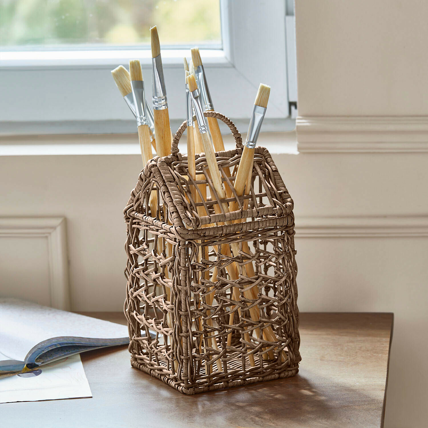 Panier Koboone Porte-pinceaux en osier brun en forme de maison avec pinceaux sur une table en bois