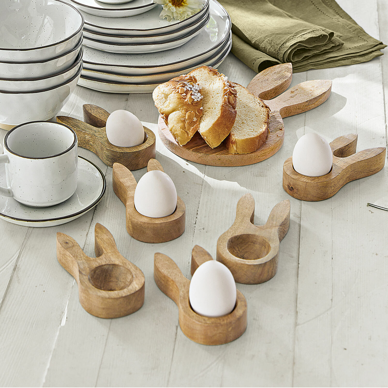 Lot de 6 coquetiers Nante Porte-œufs en bois en forme d'oreilles de lapin sur table claire avec vaisselle blanche et pain