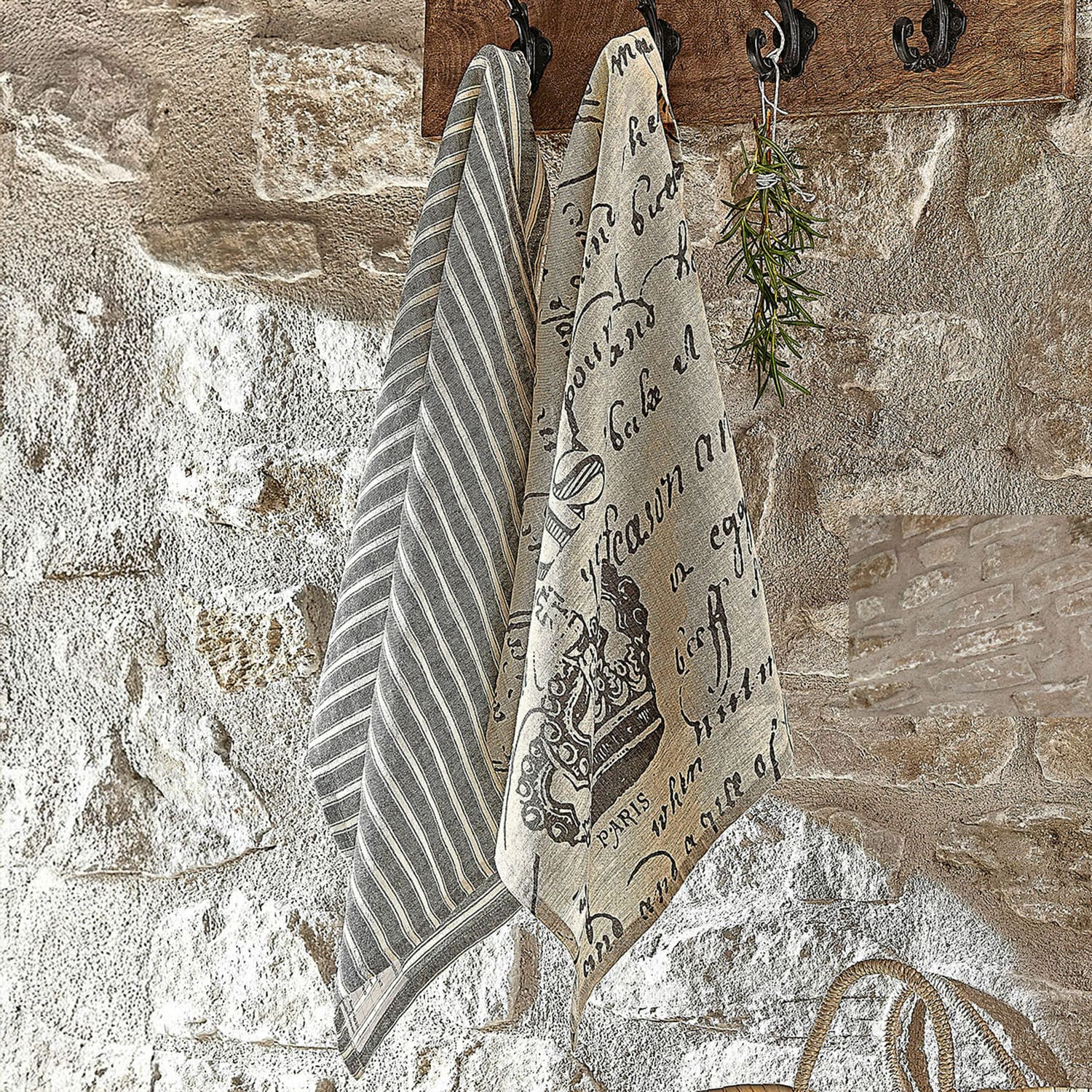 Lot de 2 torchons Fleurissant Torchons en lin rayés et imprimés en gris et beige suspendus sur un mur en pierre rustique