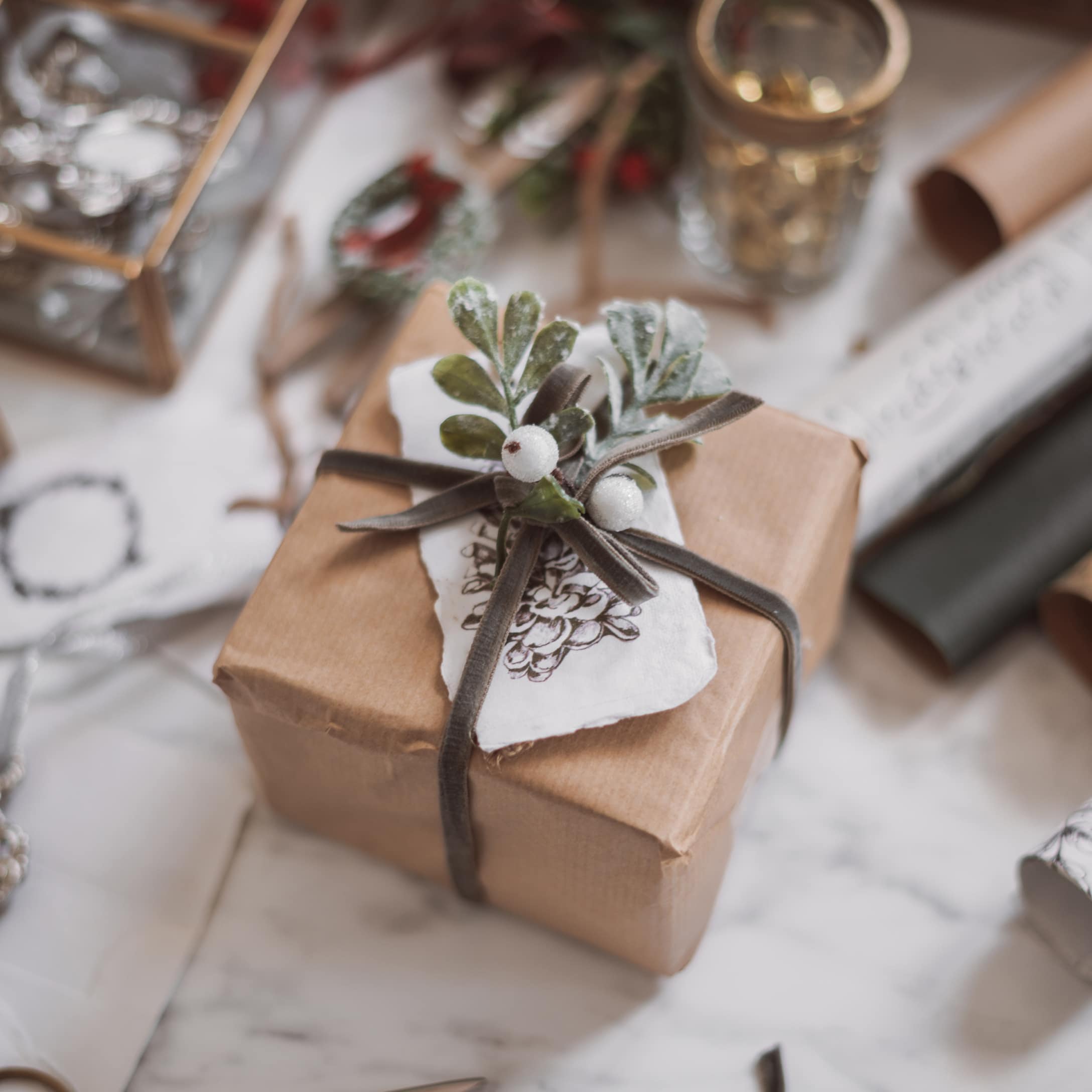 Cadeau emballé dans du papier kraft brun avec ruban et feuillage vert pour décoration festive