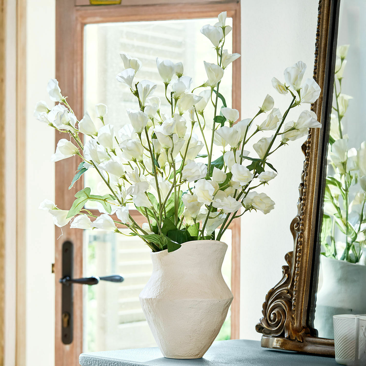 Lot de 6 fleurs Clavigny Vase en céramique blanche avec fleurs blanches décoratives sur une table près d'un miroir ancien