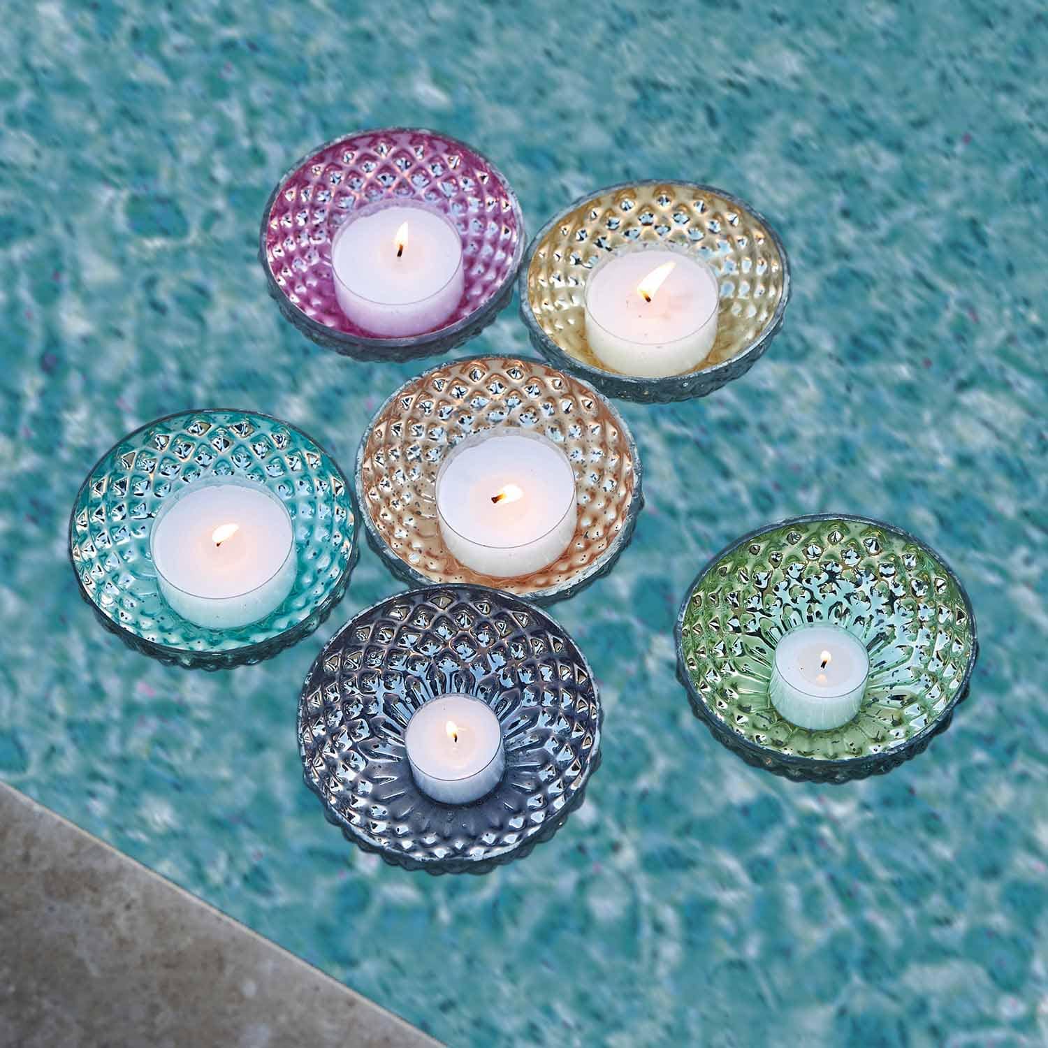 Ensemble de photophores en verre coloré avec bougies blanches flottant sur l'eau, décoration extérieure