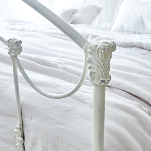 Tête de lit en métal blanc Canefield avec détails décoratifs et linge de lit clair