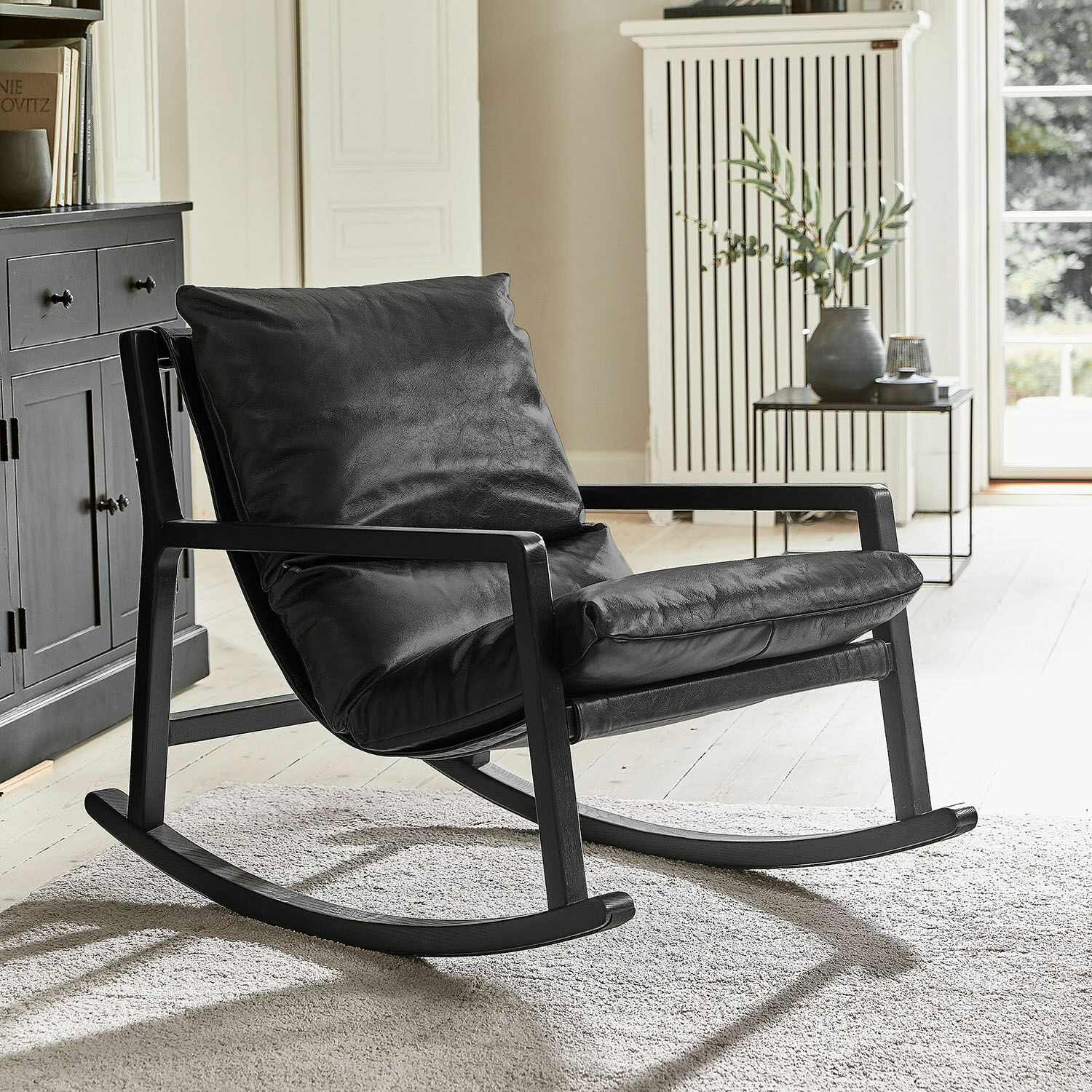Fauteuil à bascule Falconridge Fauteuil à bascule noir en cuir souple avec cadre en bois dans un salon moderne